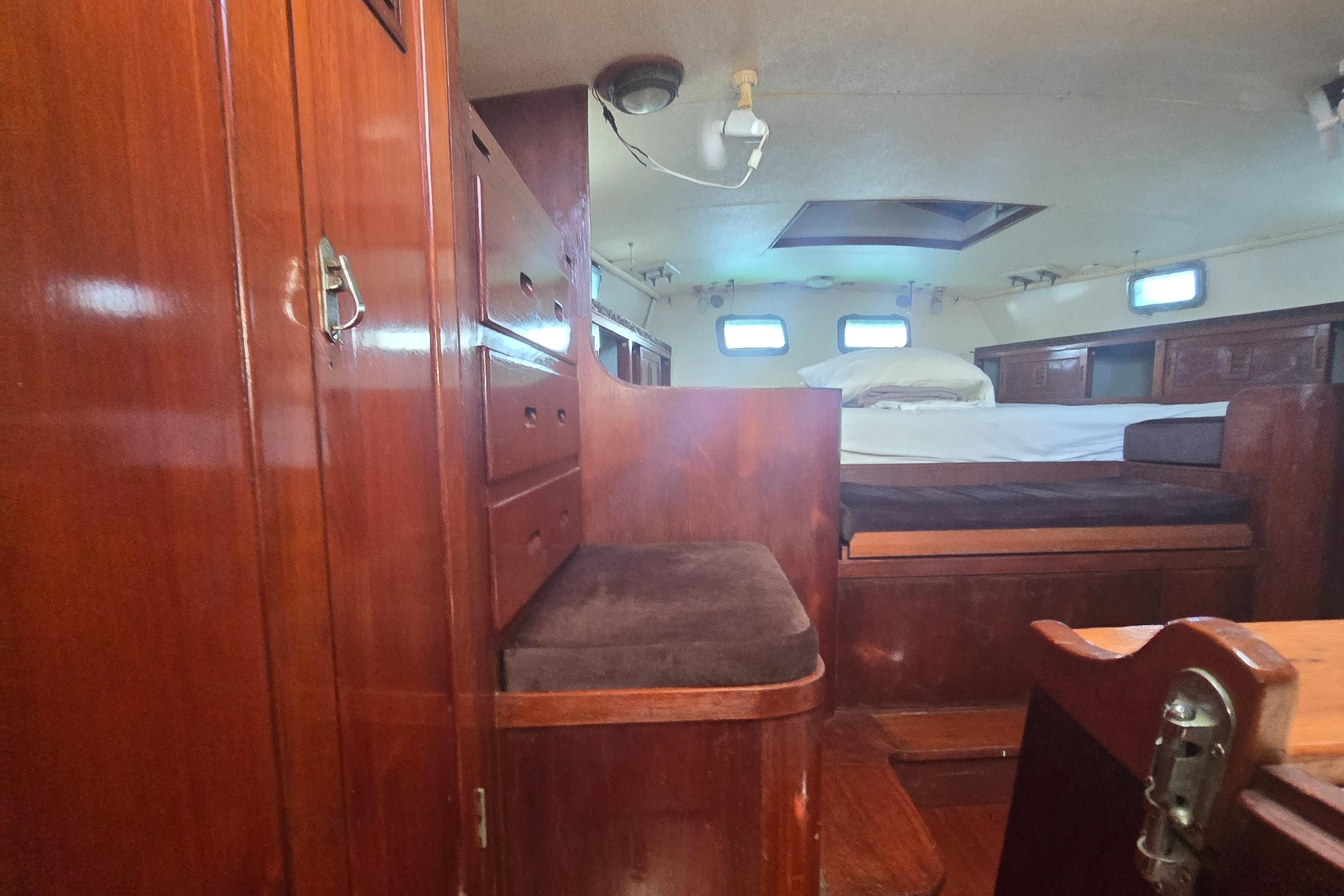 1978 Herreshoff 50 yacht interior with wooden cabinetry and cozy sleeping area.
