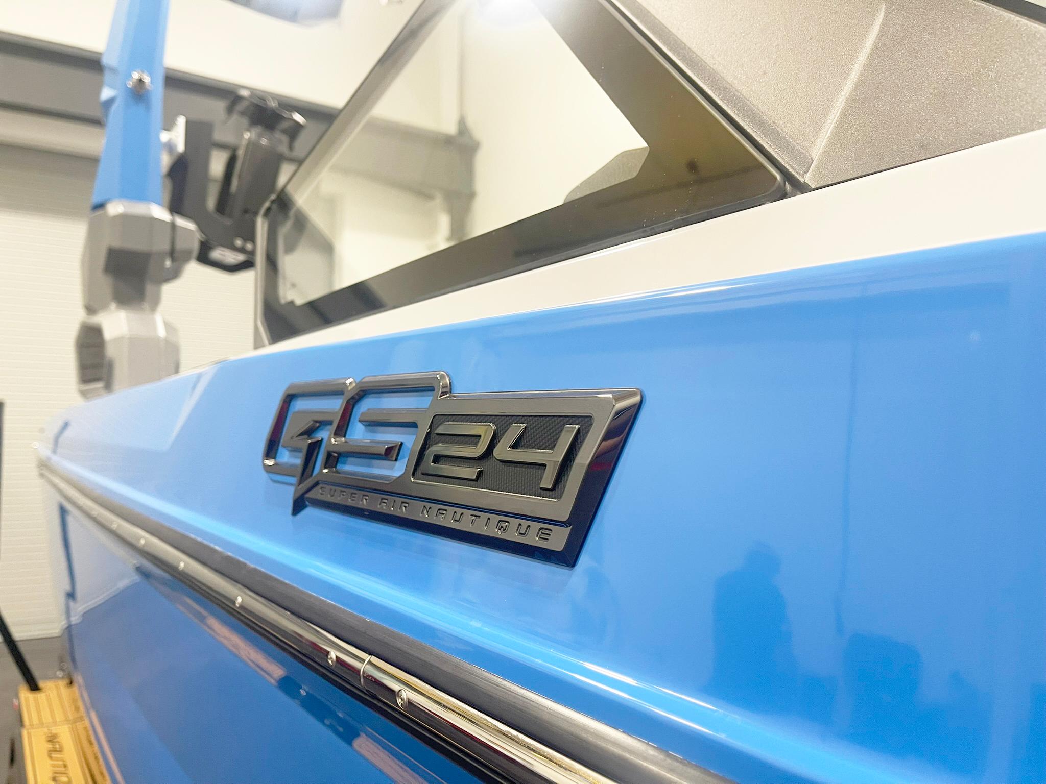 2025 Nautique Super Air Nautique GS24 boat, close-up of blue exterior and model emblem.