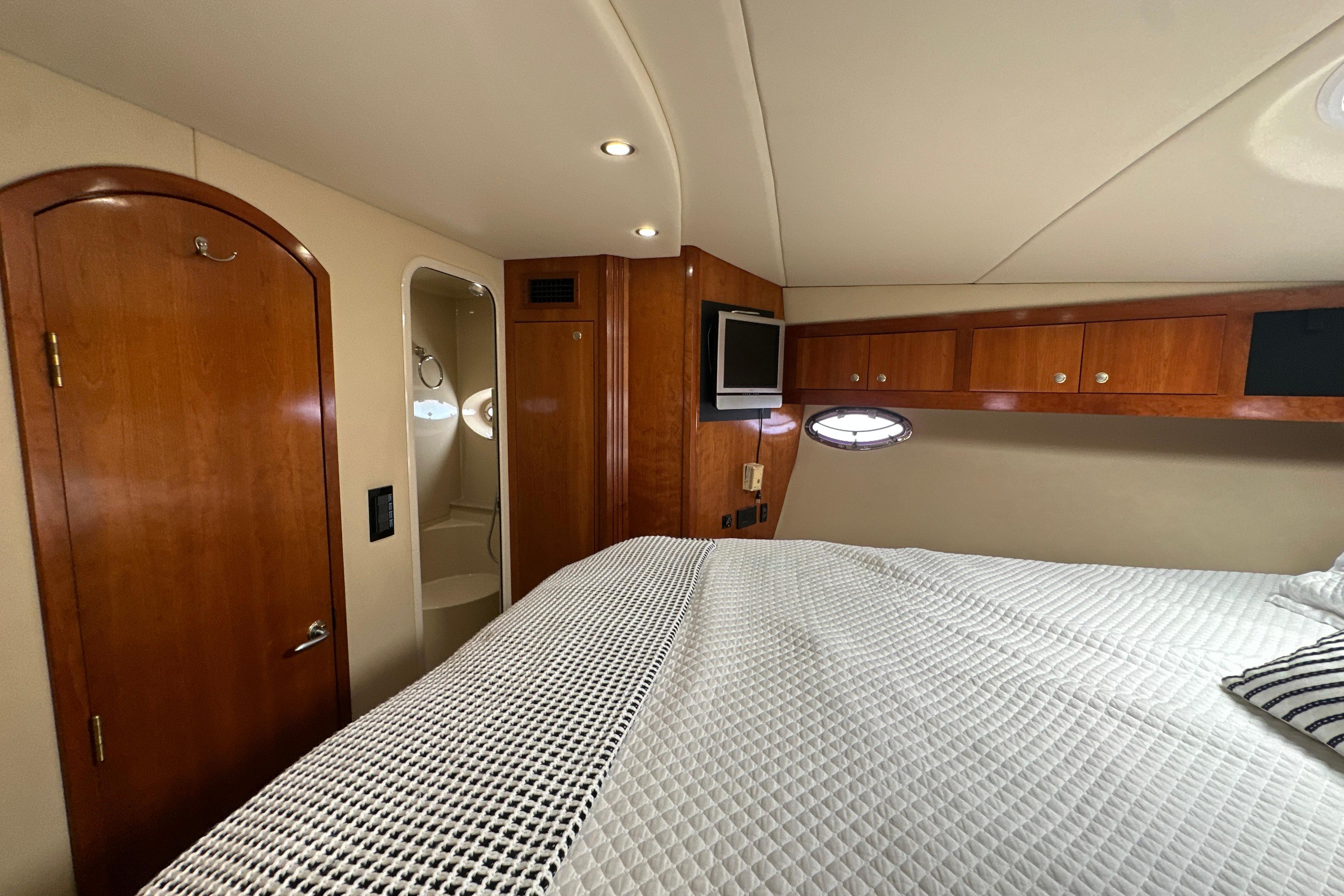 Luxurious 2004 Cruisers Yachts 405 Express Motoryacht cabin with elegant wood finishes.