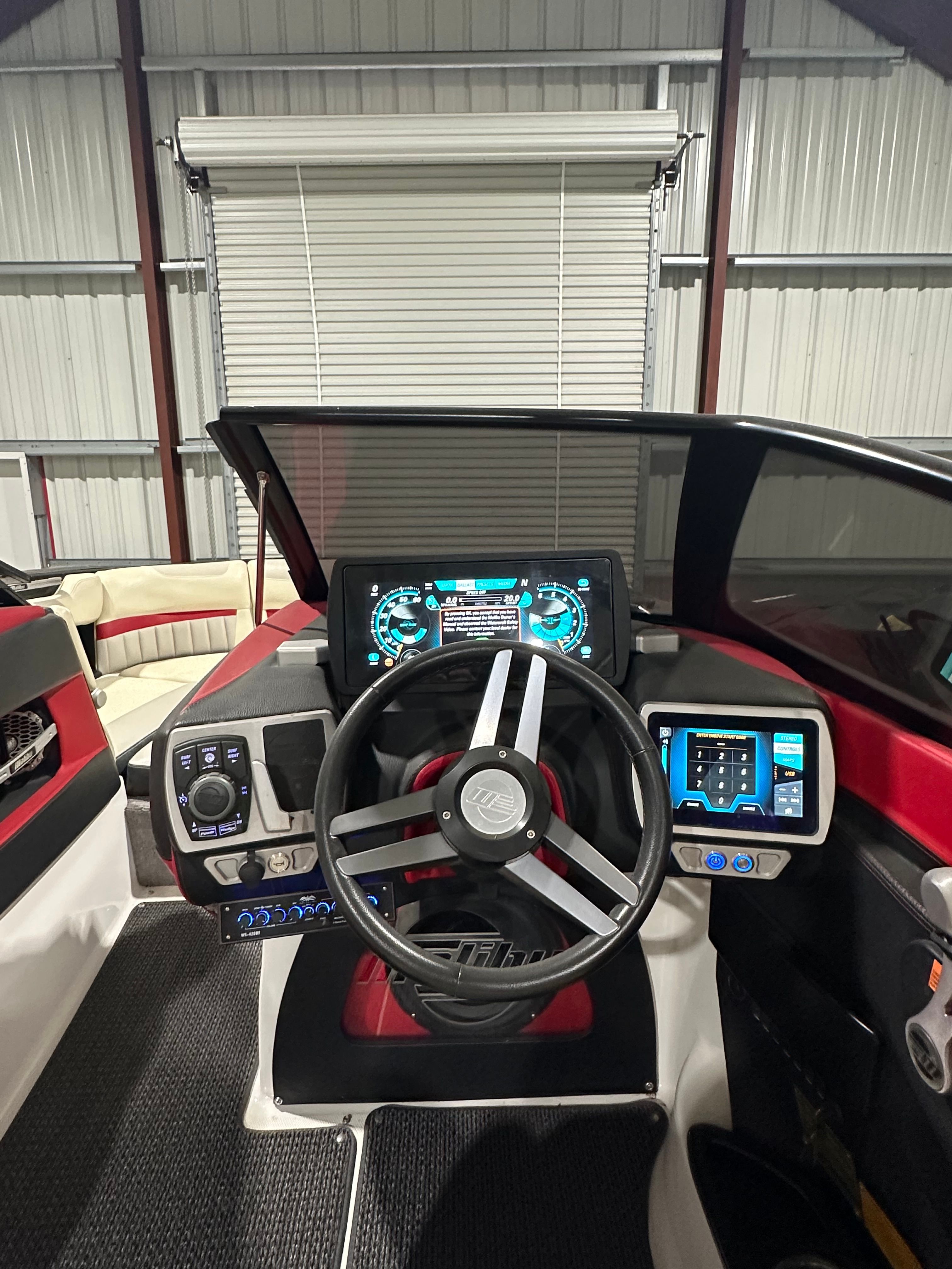 The cockpit of a Malibu Wakesetter 24 MXZ with modern instruments and a stylish steering wheel.
