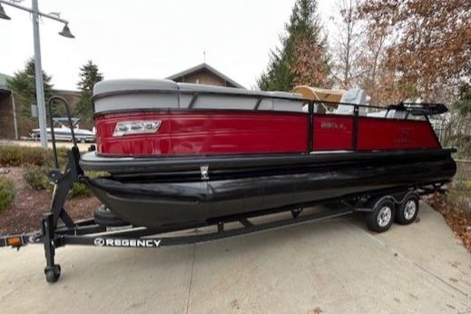 2023 Regency 230 LE3 Sport pontoon boat on trailer, red and black design.