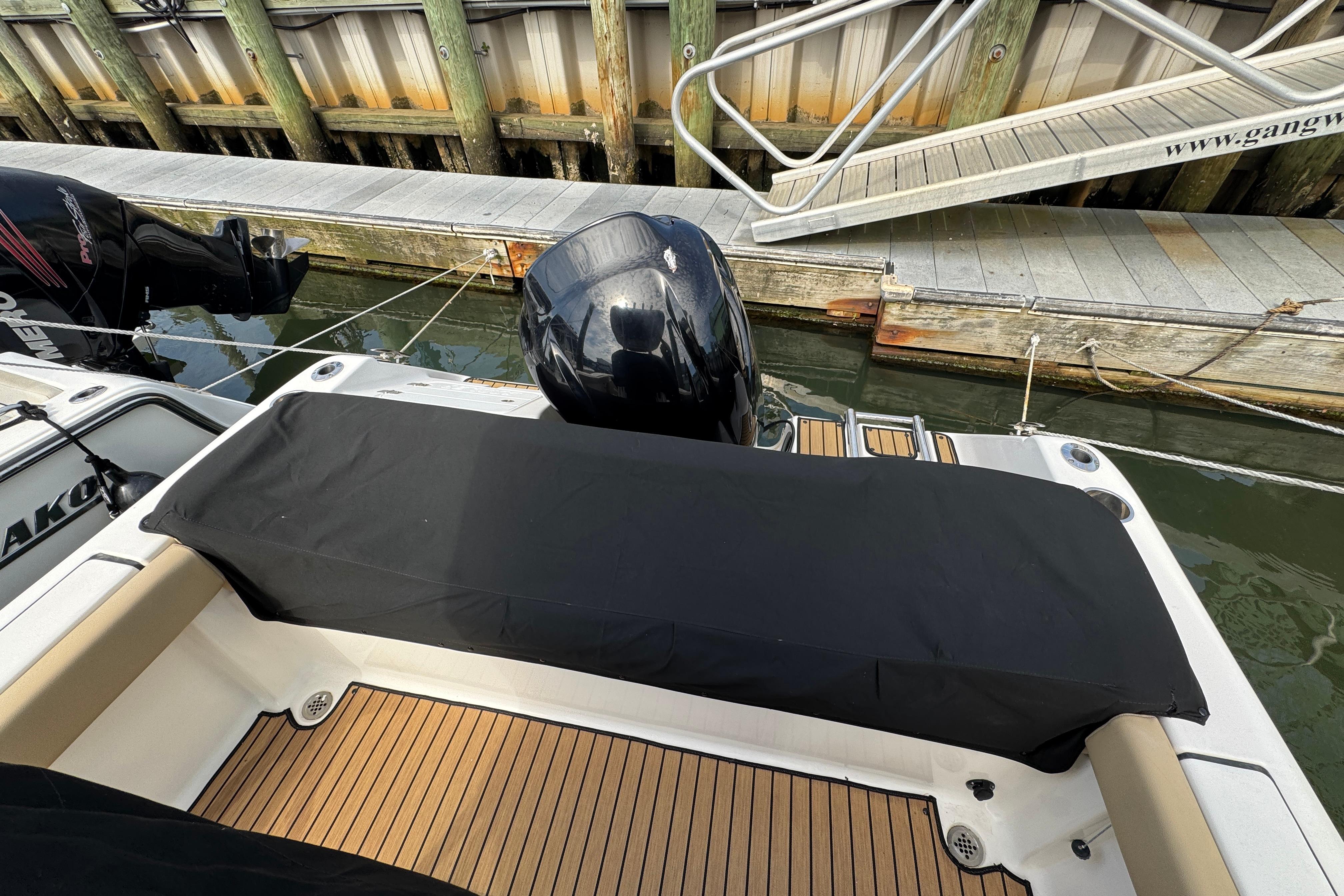 2016 Tidewater 230 LXF boat docked, featuring covered seating and outboard motor.