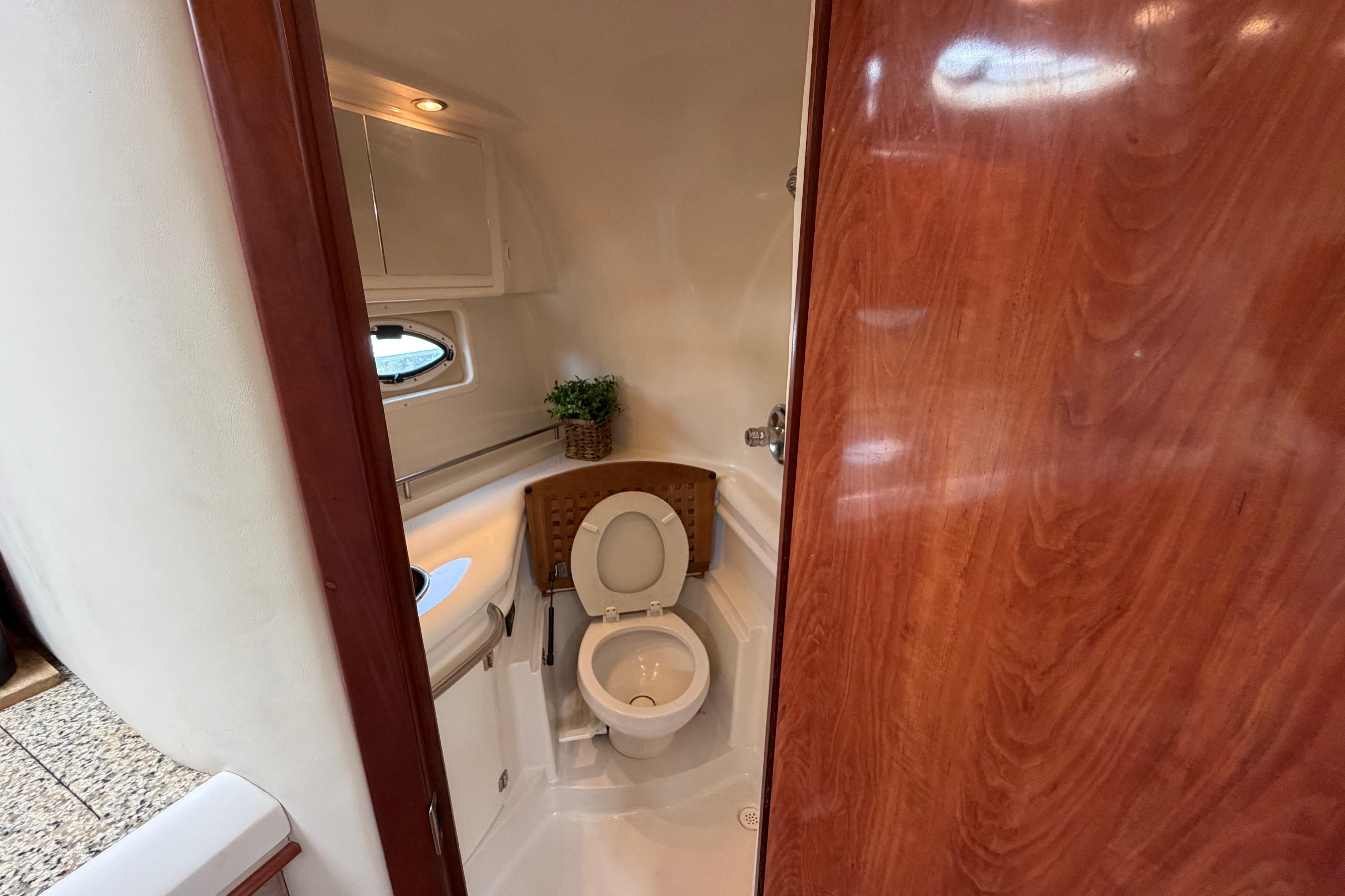 Interior of 2007 Monterey 350 Sport Yacht bathroom with wooden door and compact design.
