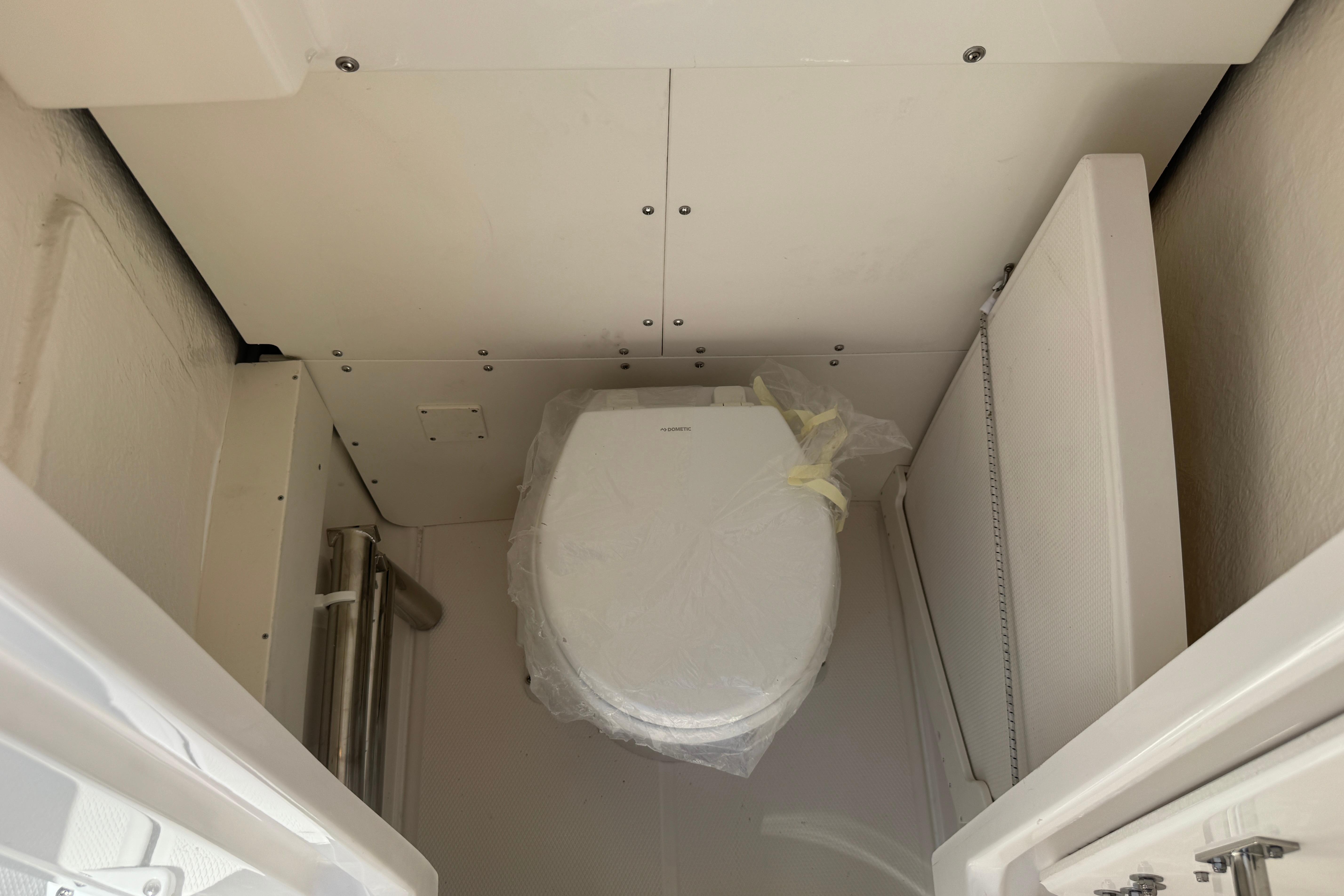2026 Robalo R250 Center Console boat interior with compact marine toilet.