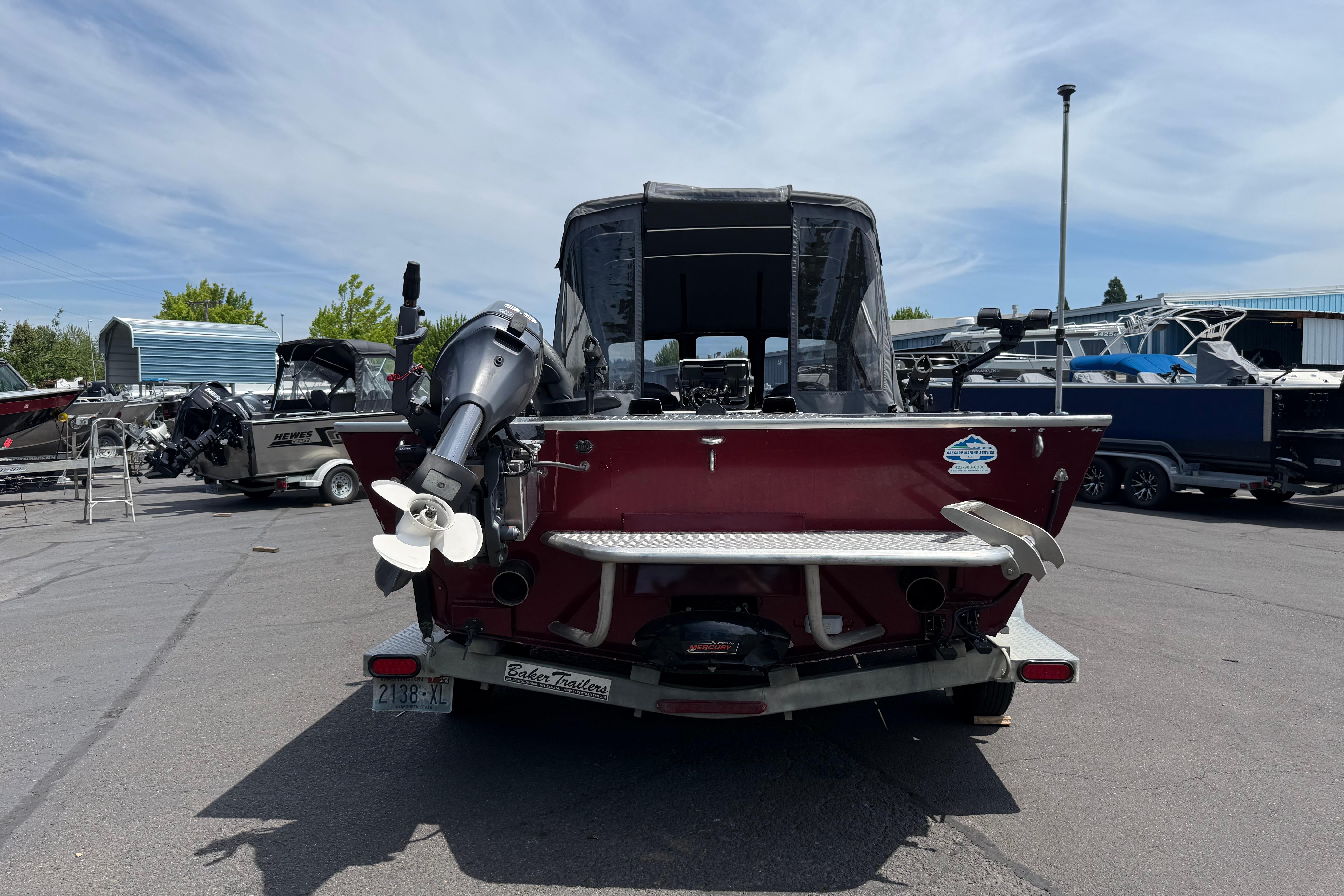 Rear view of a 2005 Willie Raptor 21' boat with outboard motor in a marina.