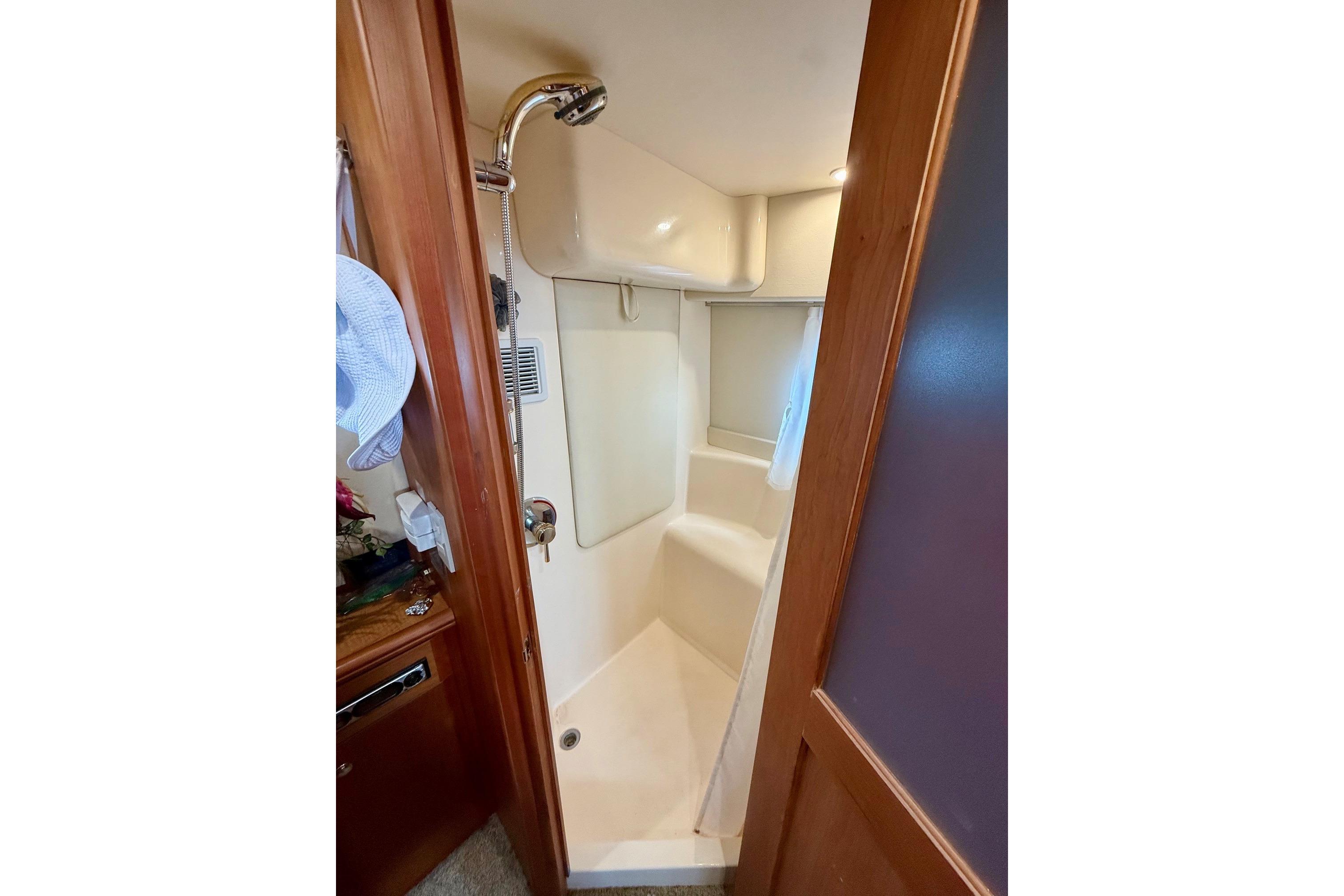 Shower area in 2004 Silverton 39 Motor Yacht, featuring compact design and wooden accents.
