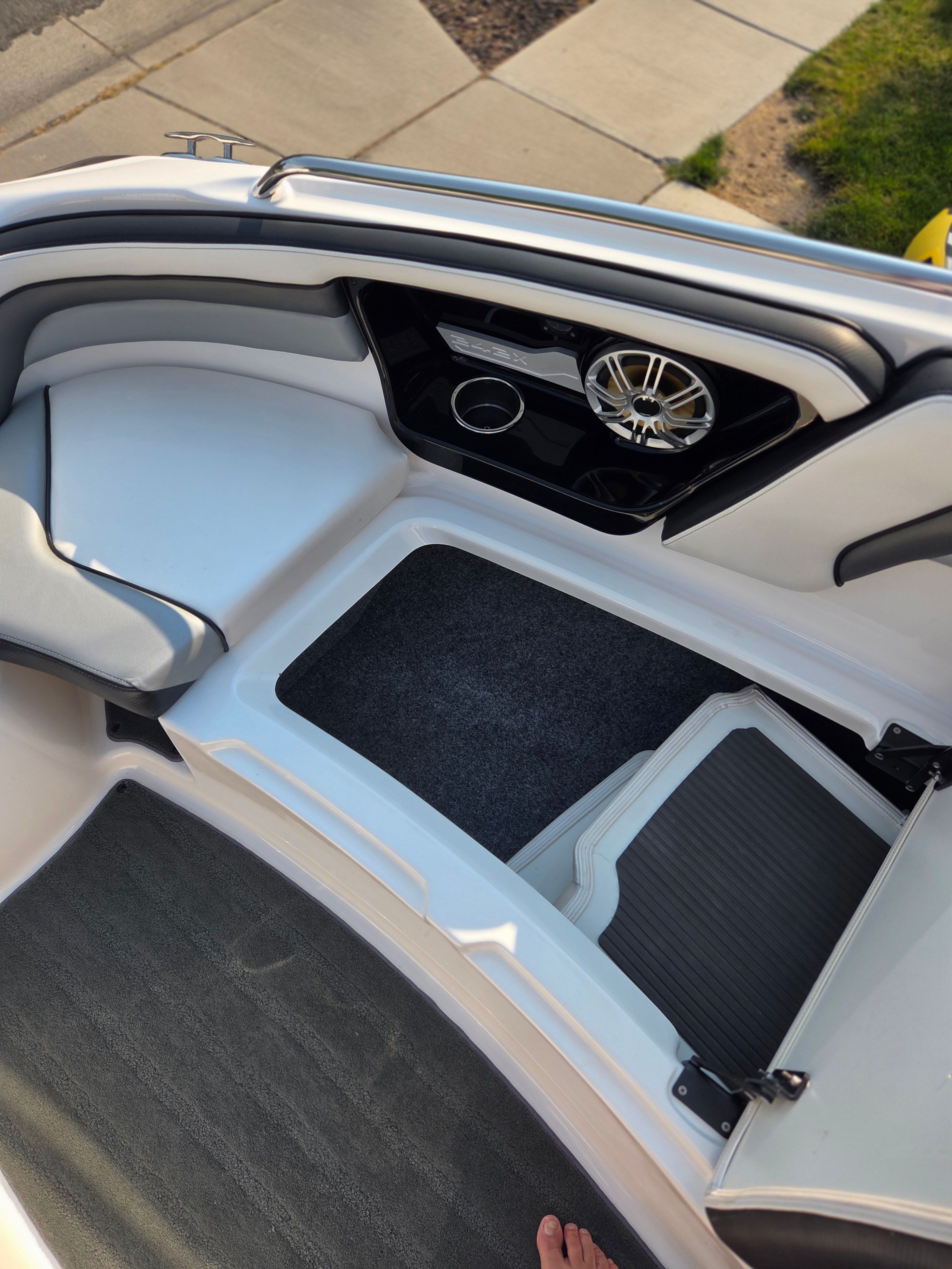 Interior of a 2016 Yamaha 242X E-Series boat with speaker and storage area.
