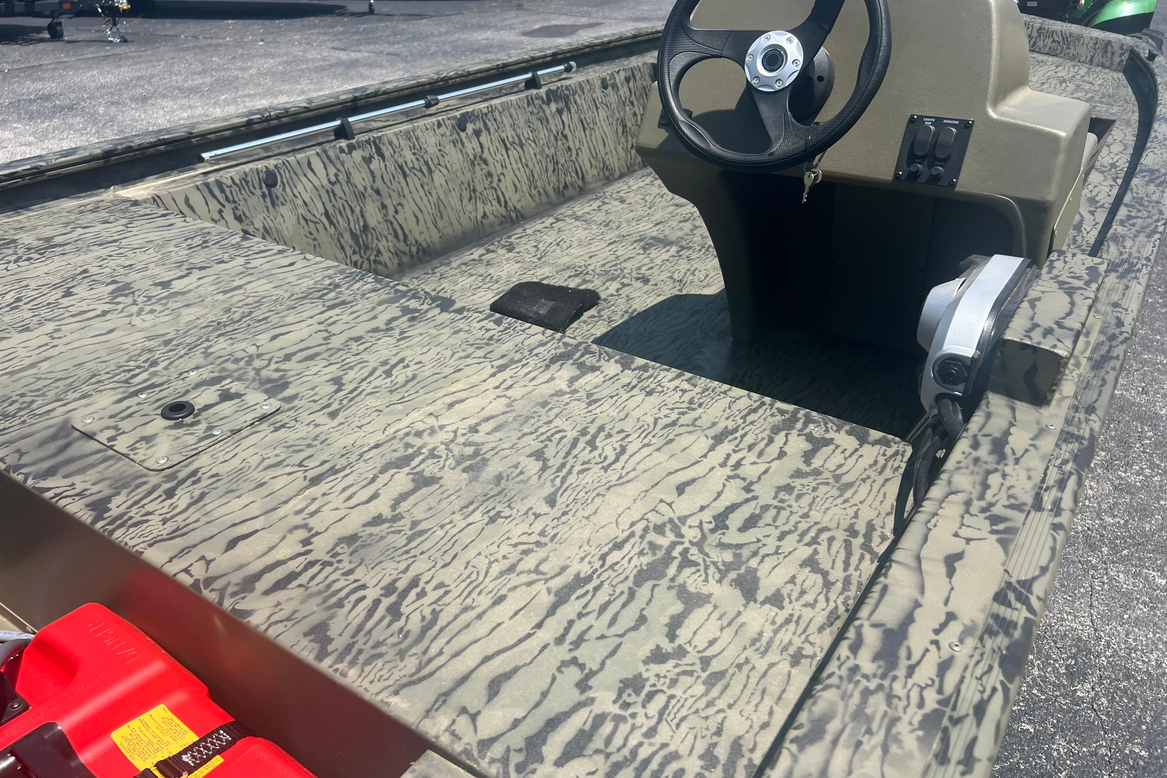 2026 Tracker Grizzly 1648 SC boat interior with camouflage pattern and steering console.