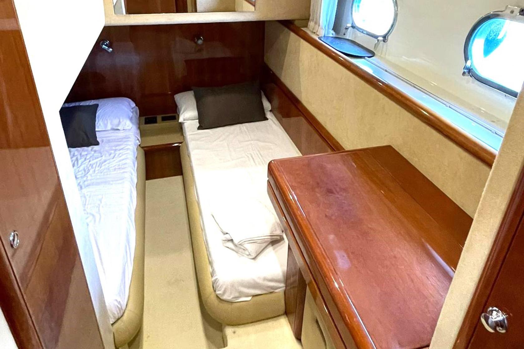 Luxurious twin cabin interior of 2002 Ferretti Yachts 620 with wooden furnishings.