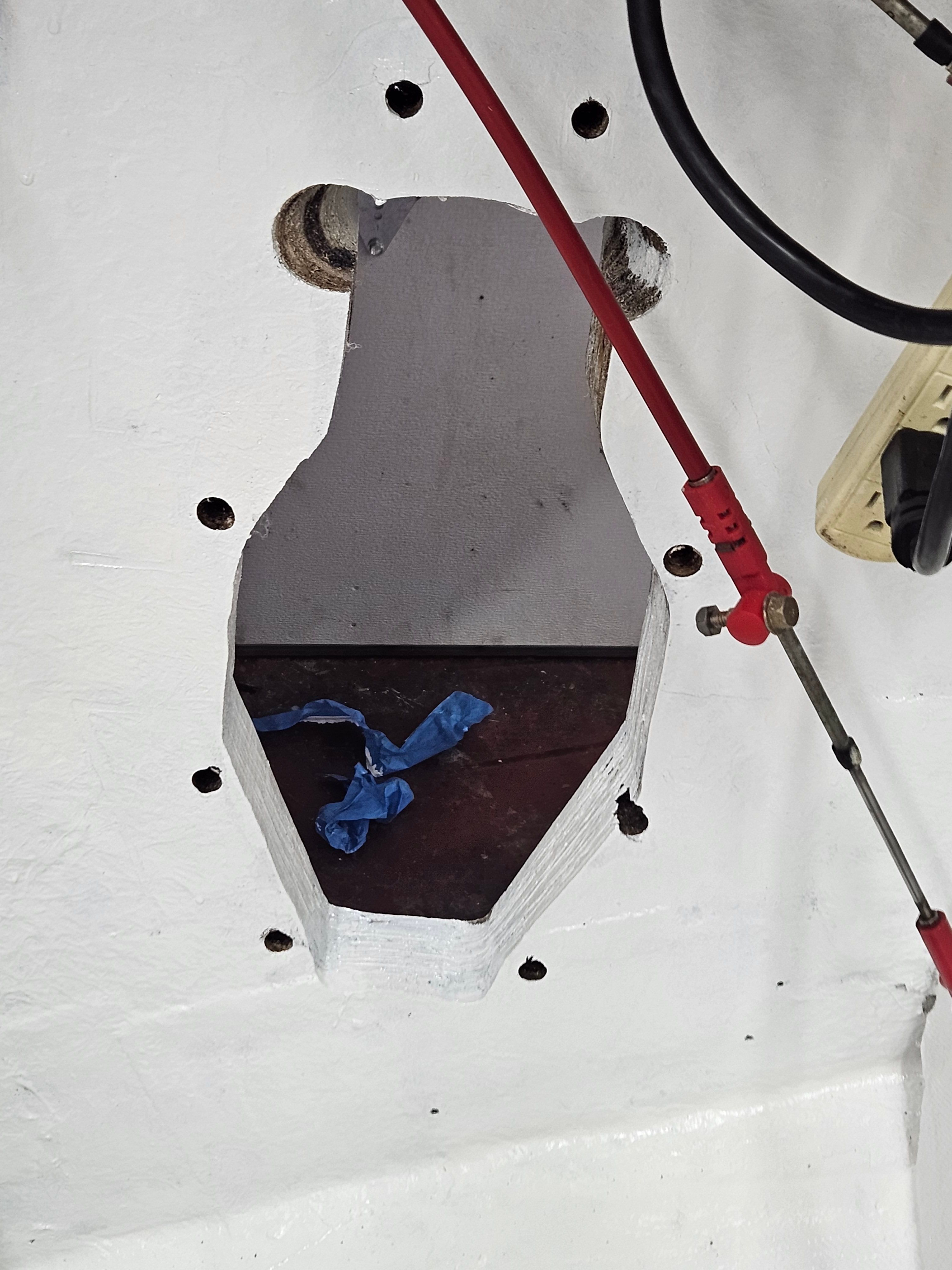 A cutout in the boat hull reveals an opening with cables and a blue ribbon.