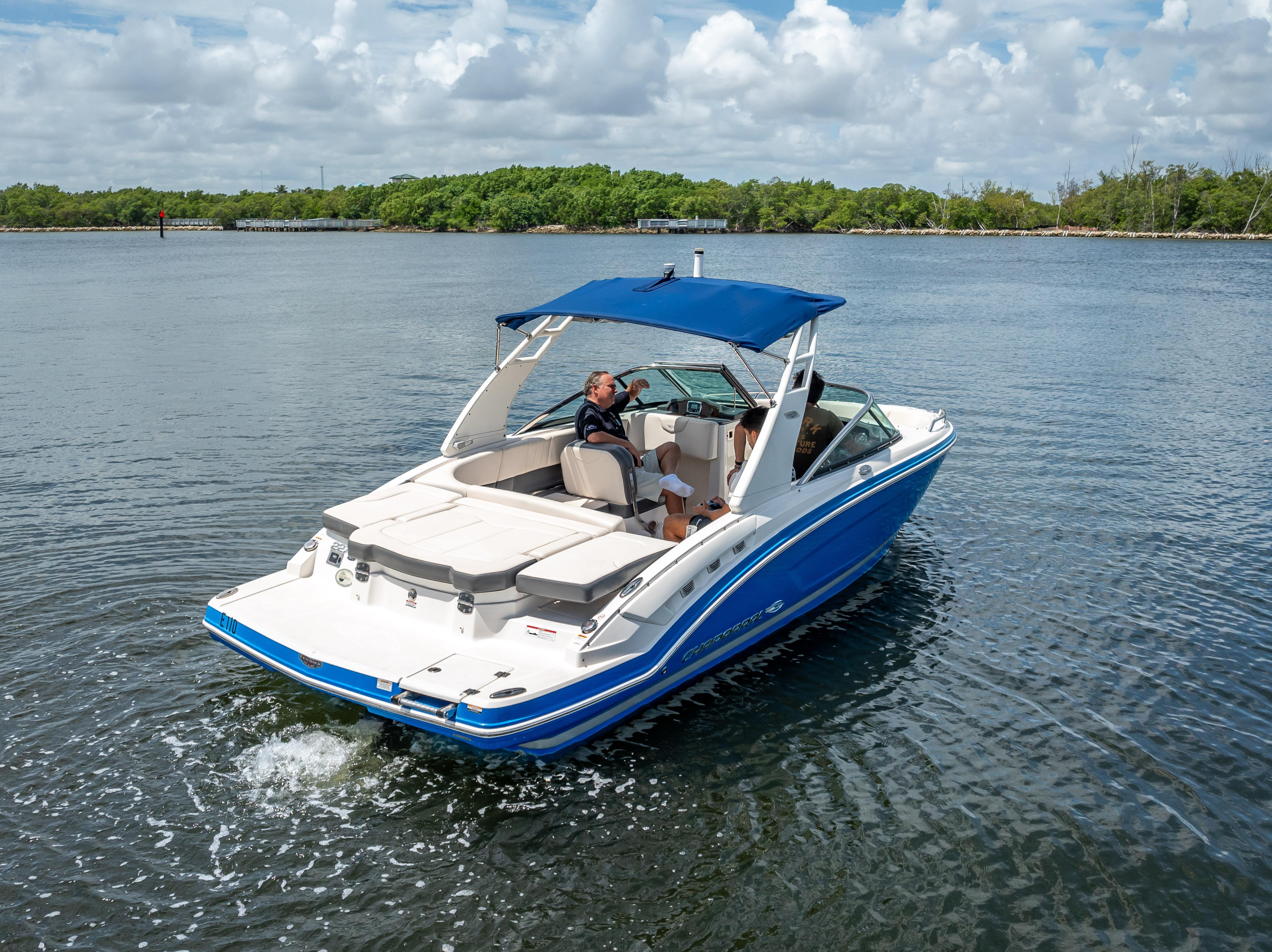 2017 Chaparral 227 SSX boat cruising on a calm lake under a cloudy sky.