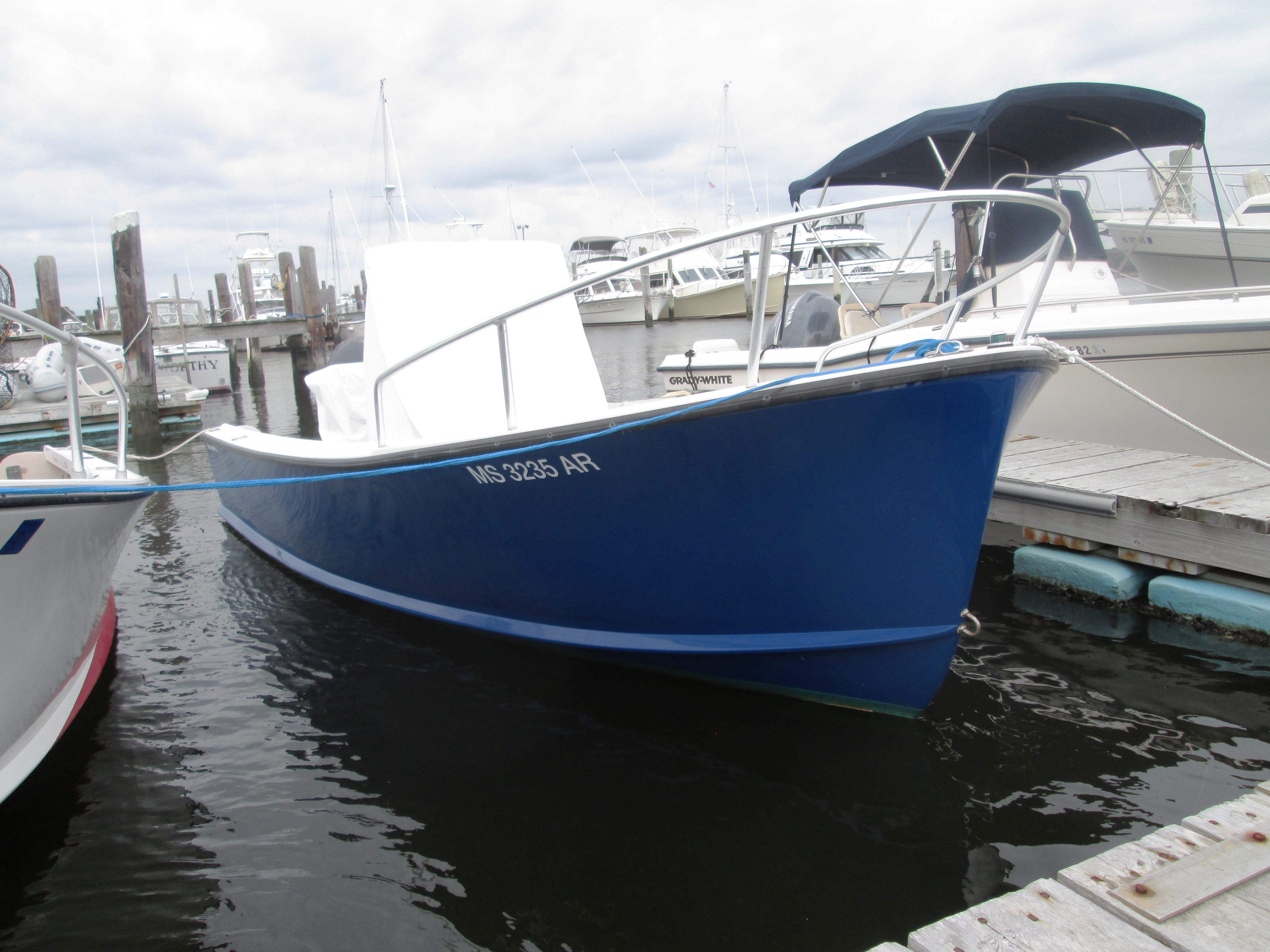 1975 Tripp Center Console boat docked at a marina, featuring a sleek blue hull.