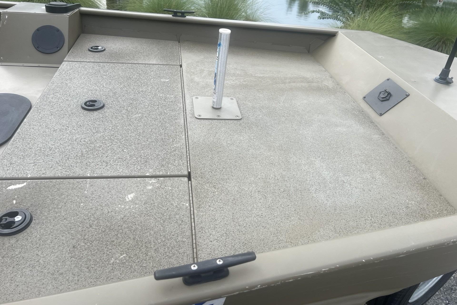 Aluminum deck of 2016 G3 1756 SC boat with storage compartments and pole mount.
