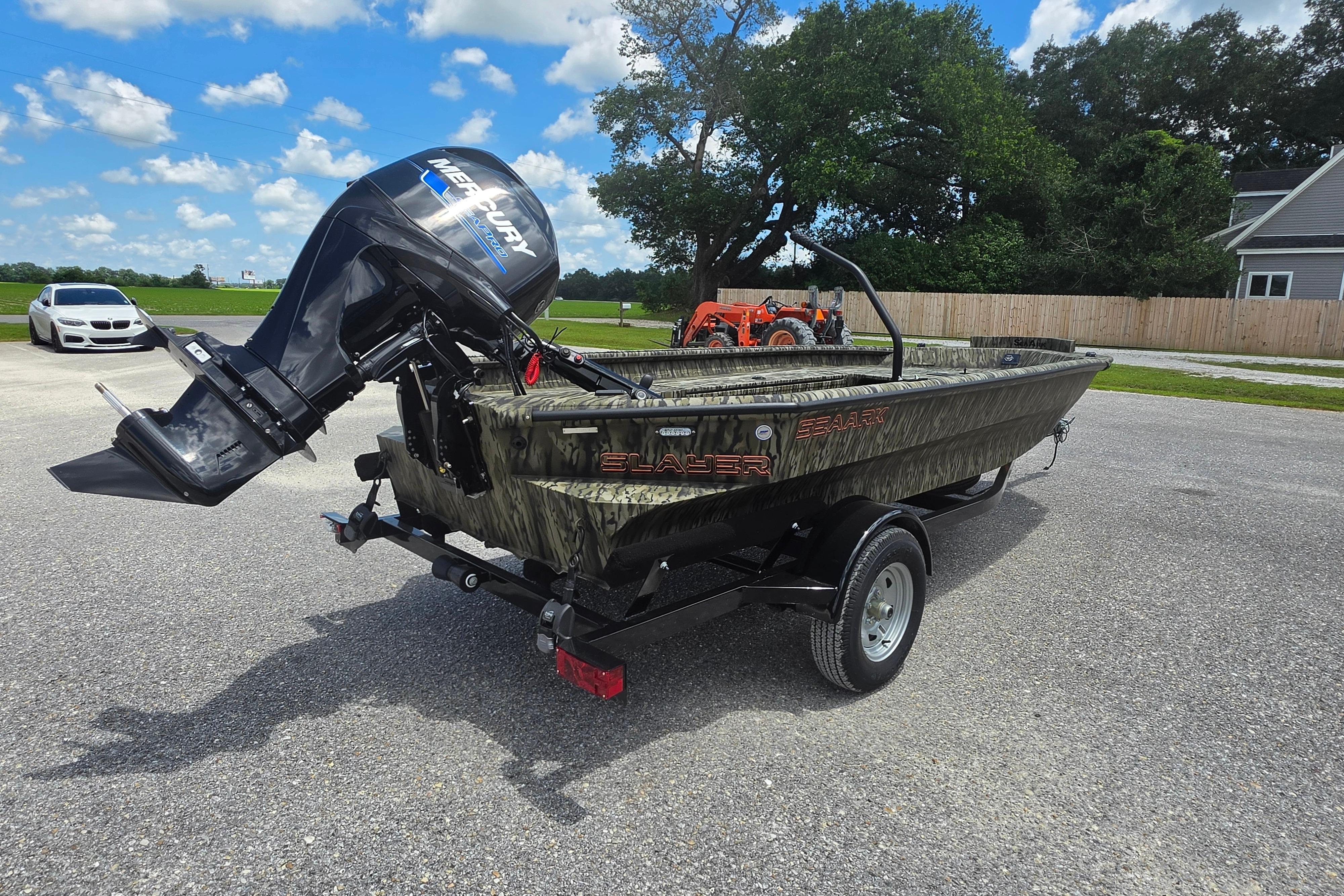 2025 SeaArk 1752 Slayer boat with Mercury outboard motor on trailer, parked outdoors.
