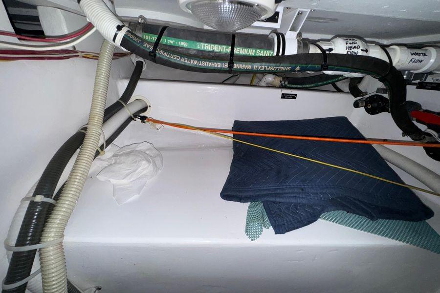 Engine room of 2002 Viking 61 Enclosed Bridge with hoses and folded blankets.
