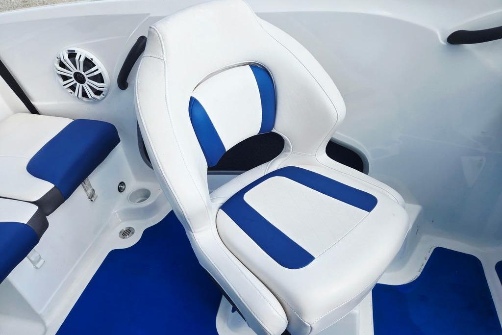 White and blue boat seat in a 2018 Tahoe 450 TS, featuring a speaker and cup holder.