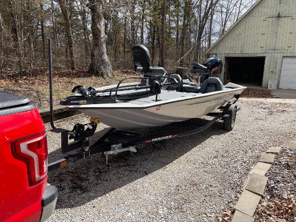 2021 Tracker Pro 195 XTE boat on trailer, parked in a wooded driveway.