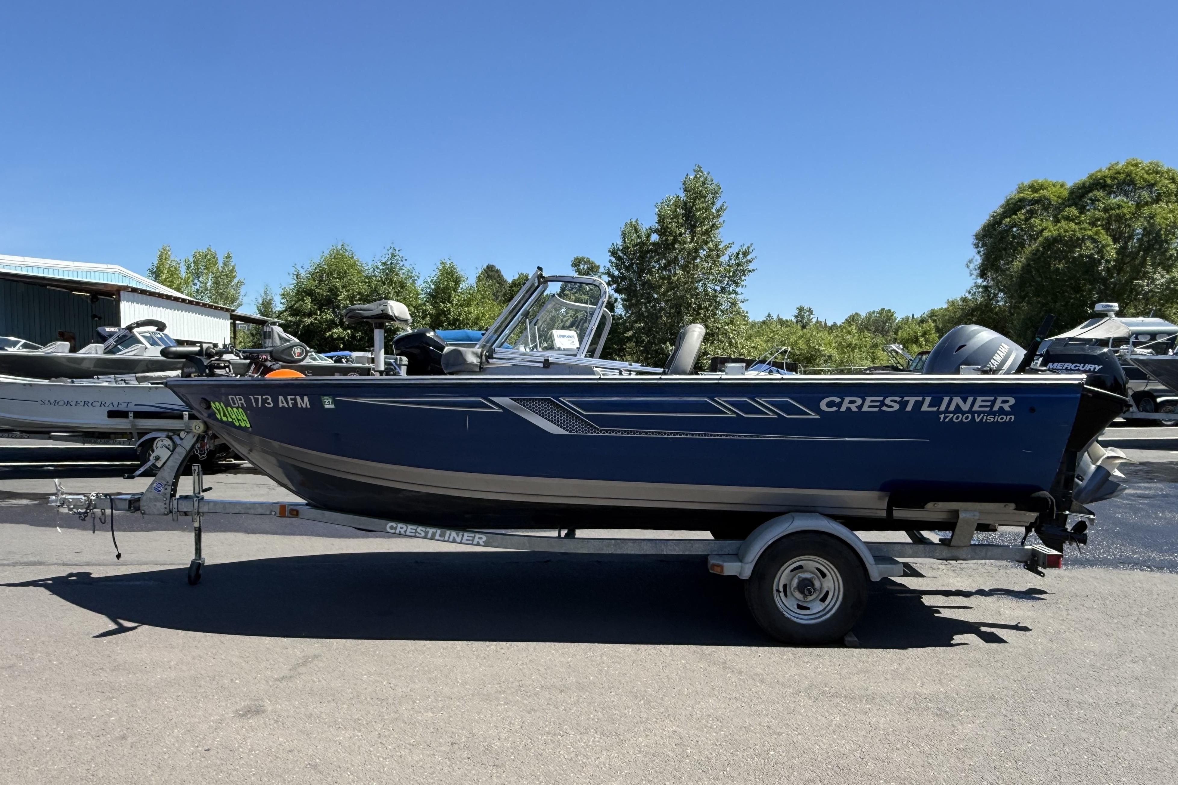 2016 Crestliner 1700 Vision boat on trailer, parked outdoors under clear blue sky.