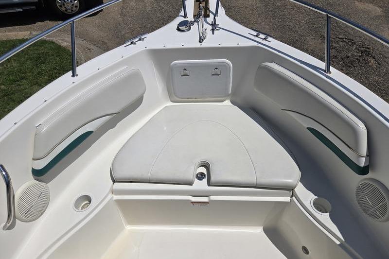 2004 Aquasport 215 Osprey Sport boat interior with cushioned seating and storage compartments.