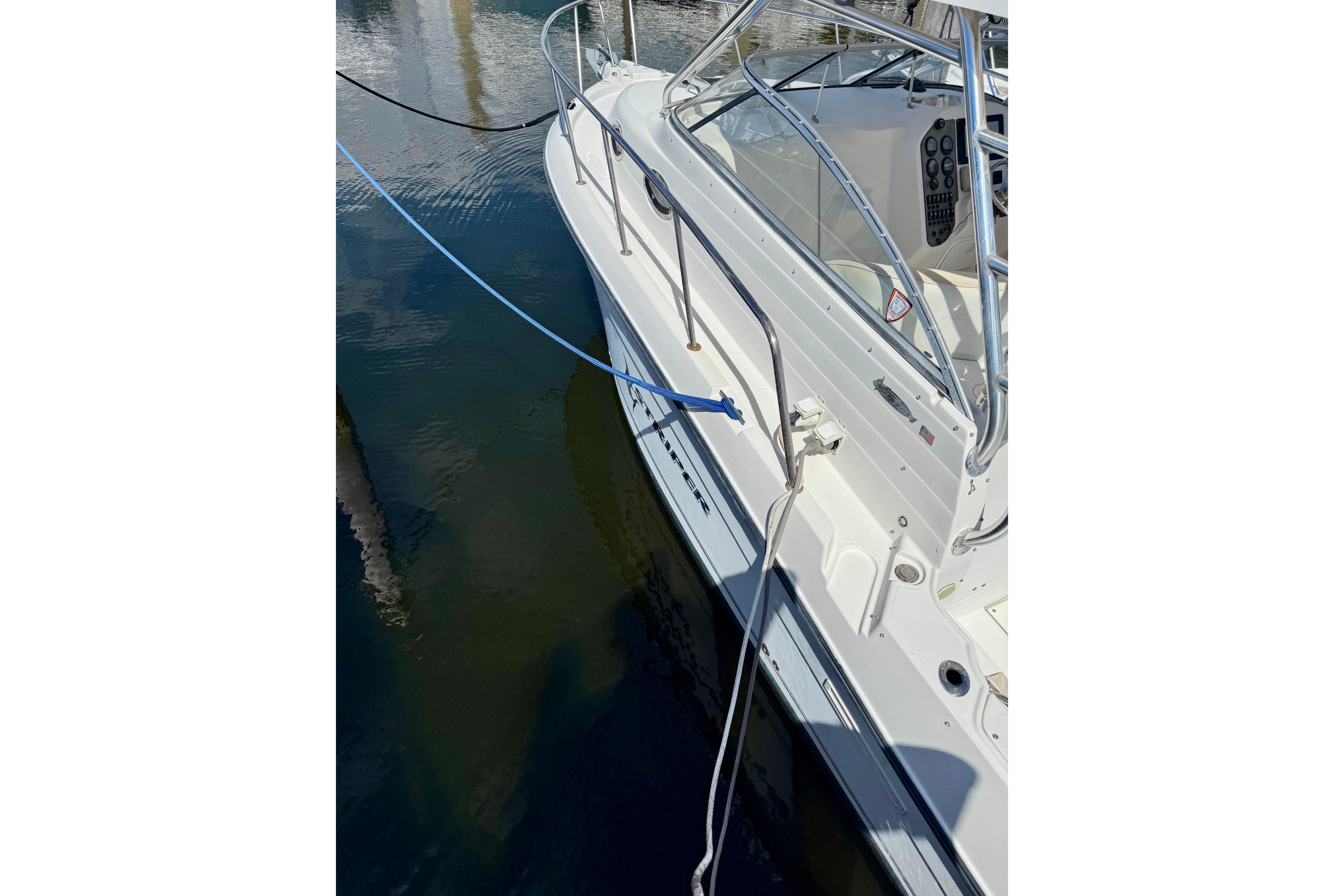 2006 Seaswirl Striper 2901 Walkaround O/B docked, showing side view and railing.
