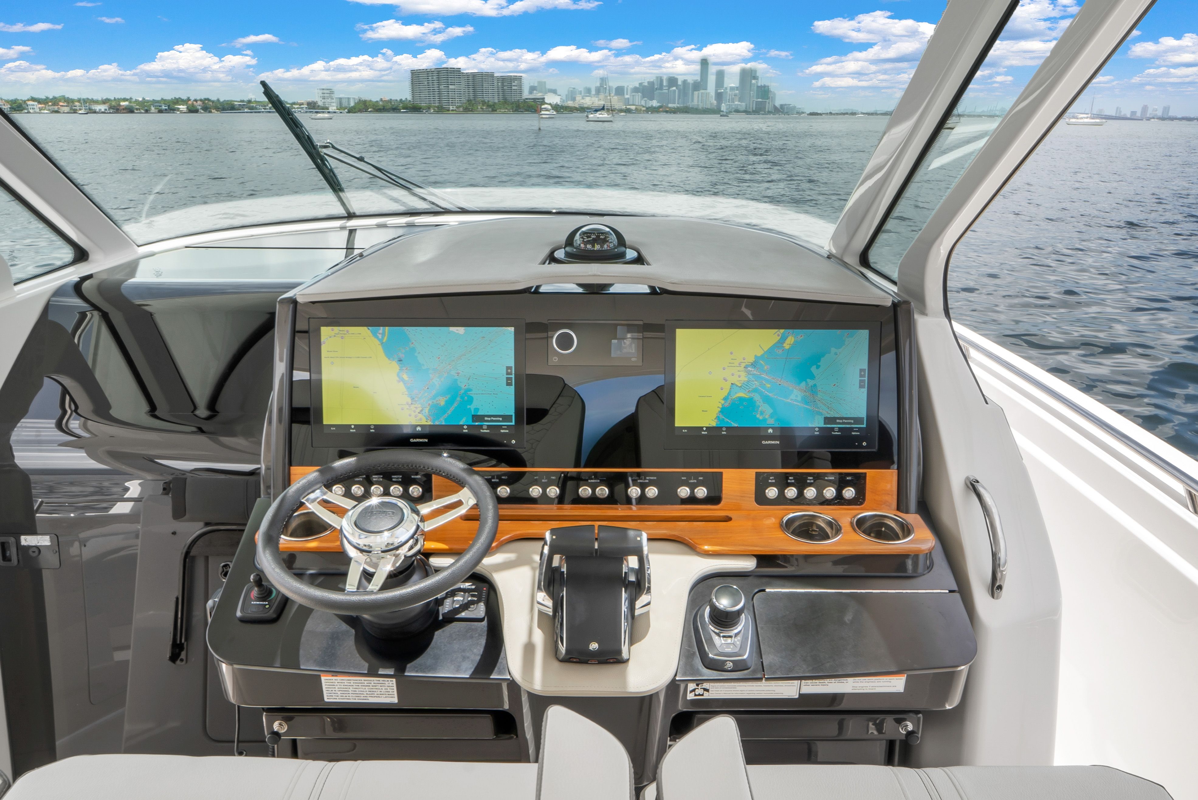 The cockpit of a Tiara Yachts 38 LS with dual screens and a steering wheel.