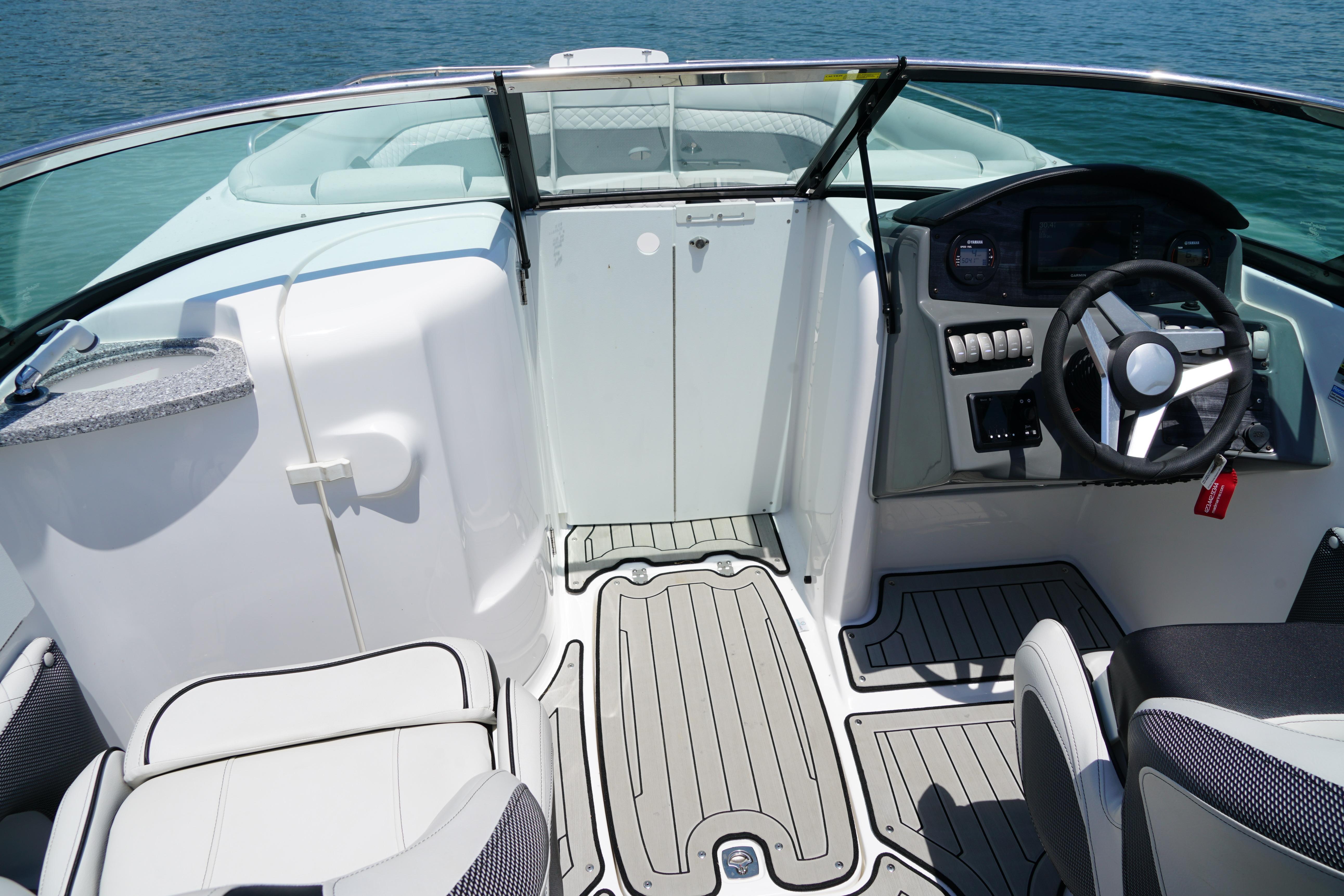 2020 Hurricane SunDeck 2486 OB boat interior with steering wheel and seating.