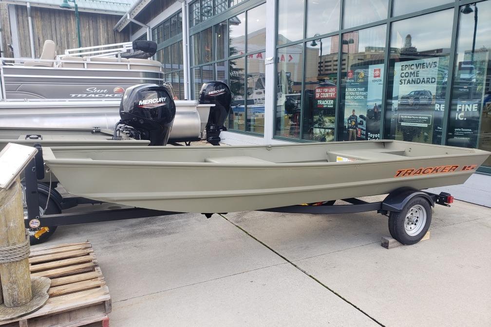 2026 Tracker Grizzly 15 Jon boat on trailer, displayed outdoors near showroom.