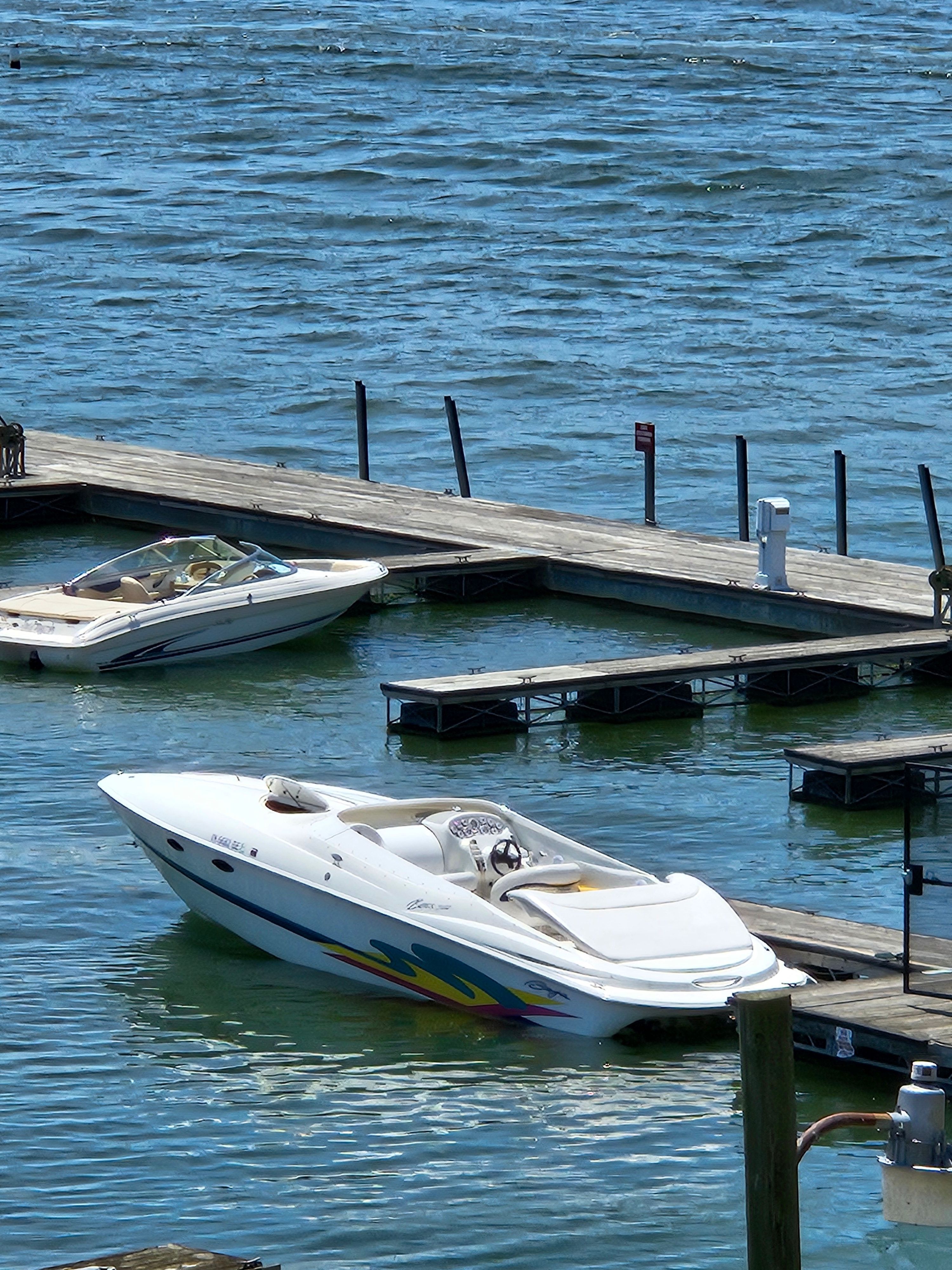A 1996 Baja 302 Boss is docked in the water. The boat features a sporty design.