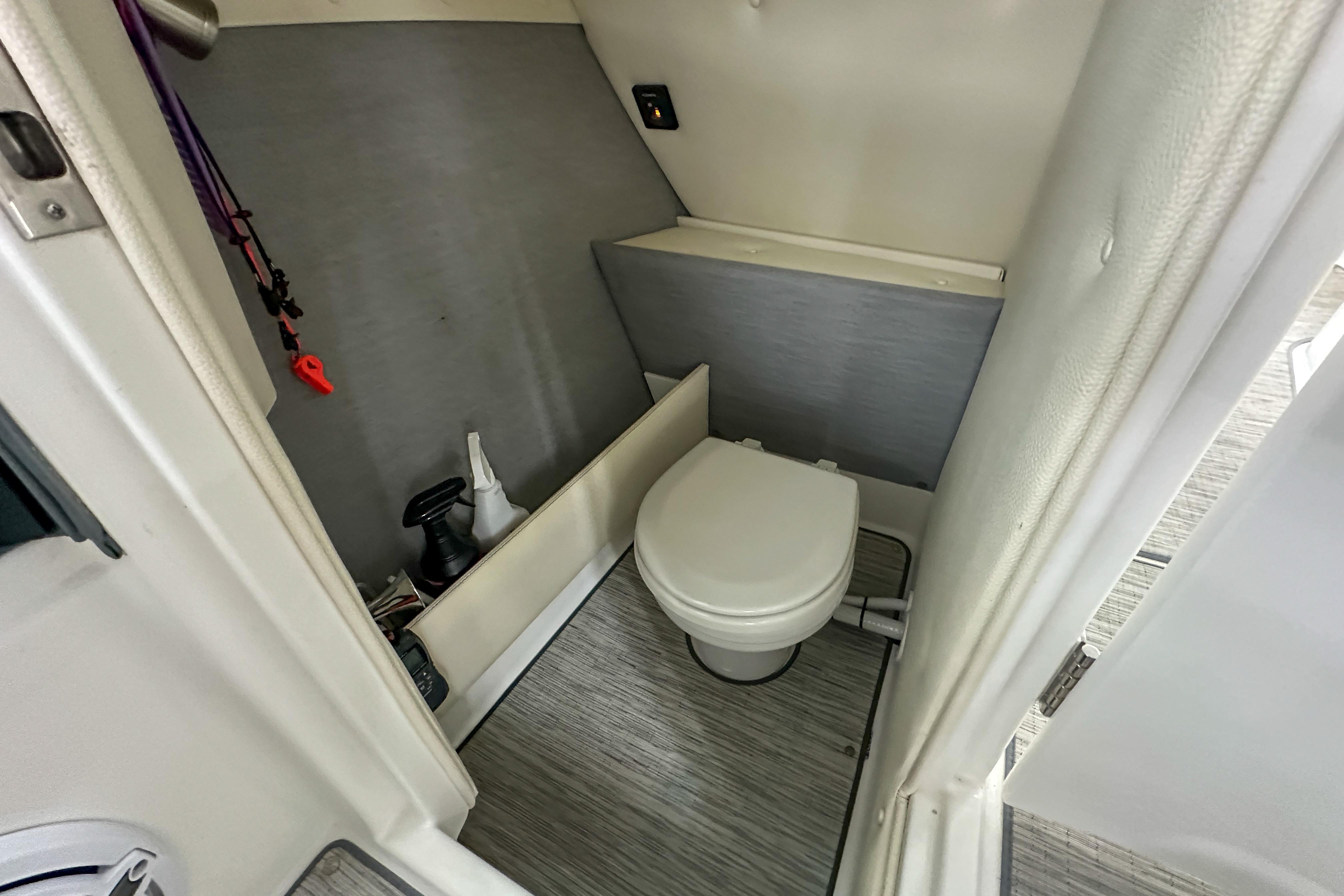 2022 Cobalt 25SC boat interior with compact bathroom and toilet.