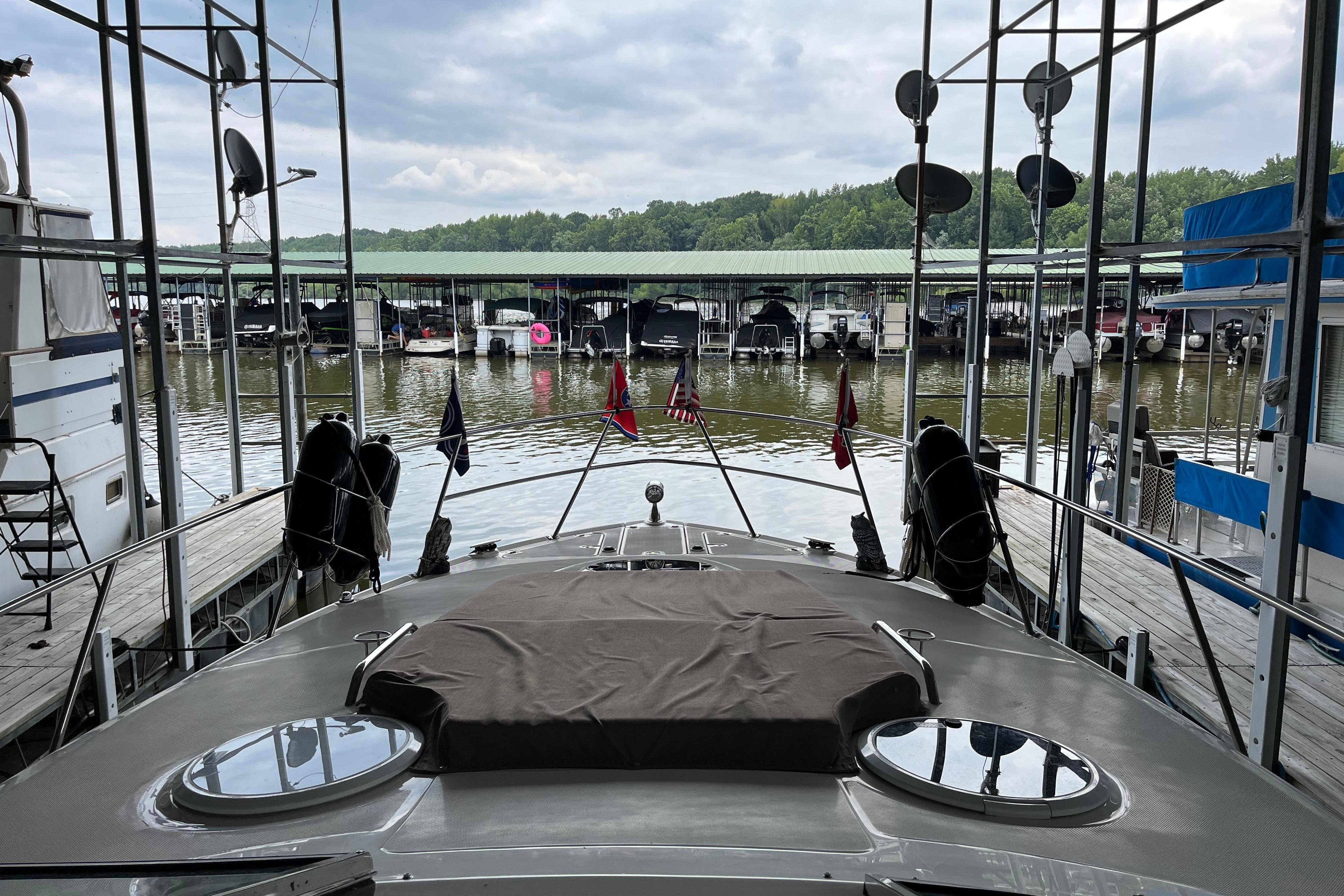2007 Regal 3760 IB COMMODORE yacht docked at marina with covered boats and lush greenery.