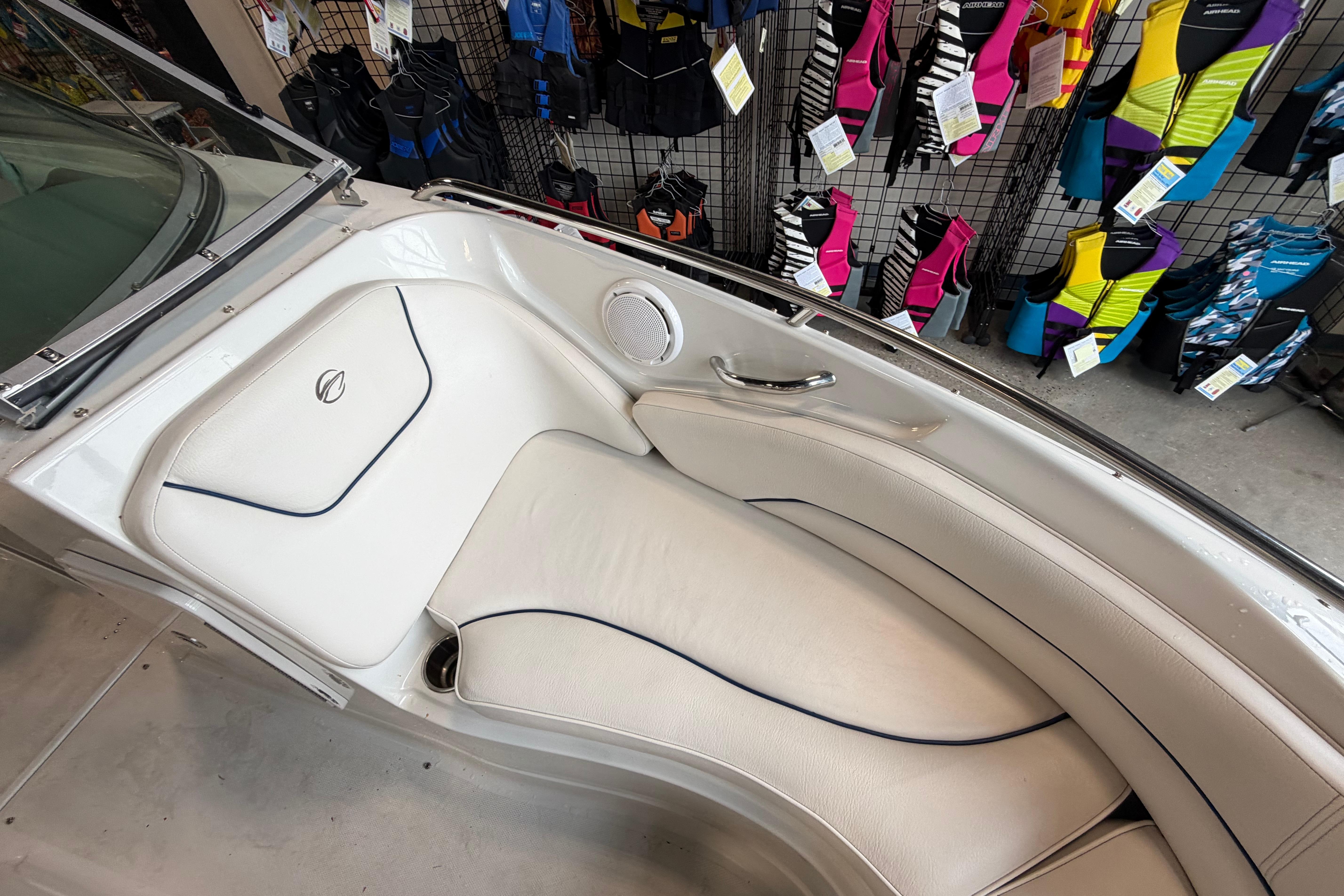 2008 Crownline 220 LS boat interior with white seating and colorful life jackets displayed.