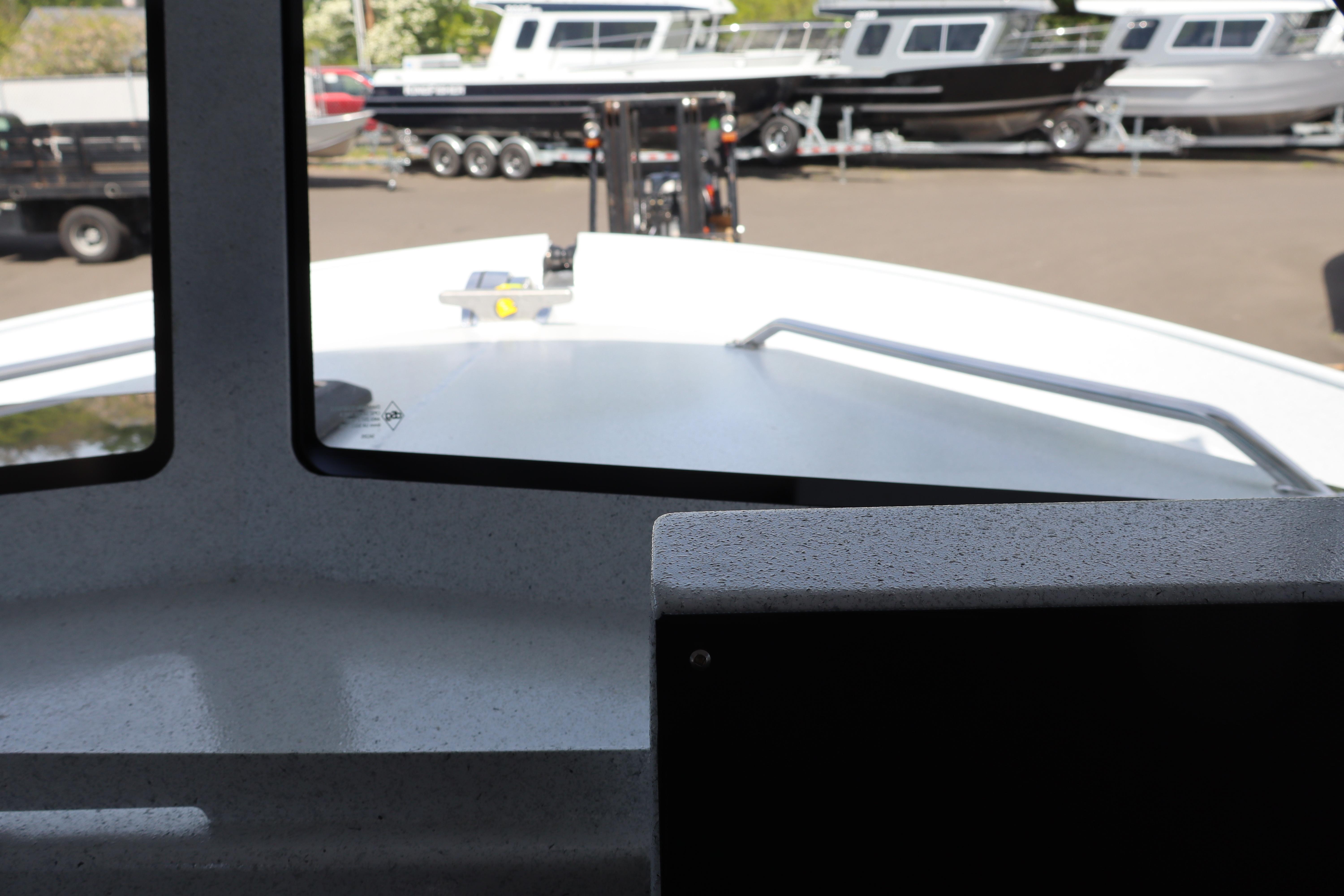 Interior view from KingFisher 25 XAC boat, showcasing the deck and parked boats outside.