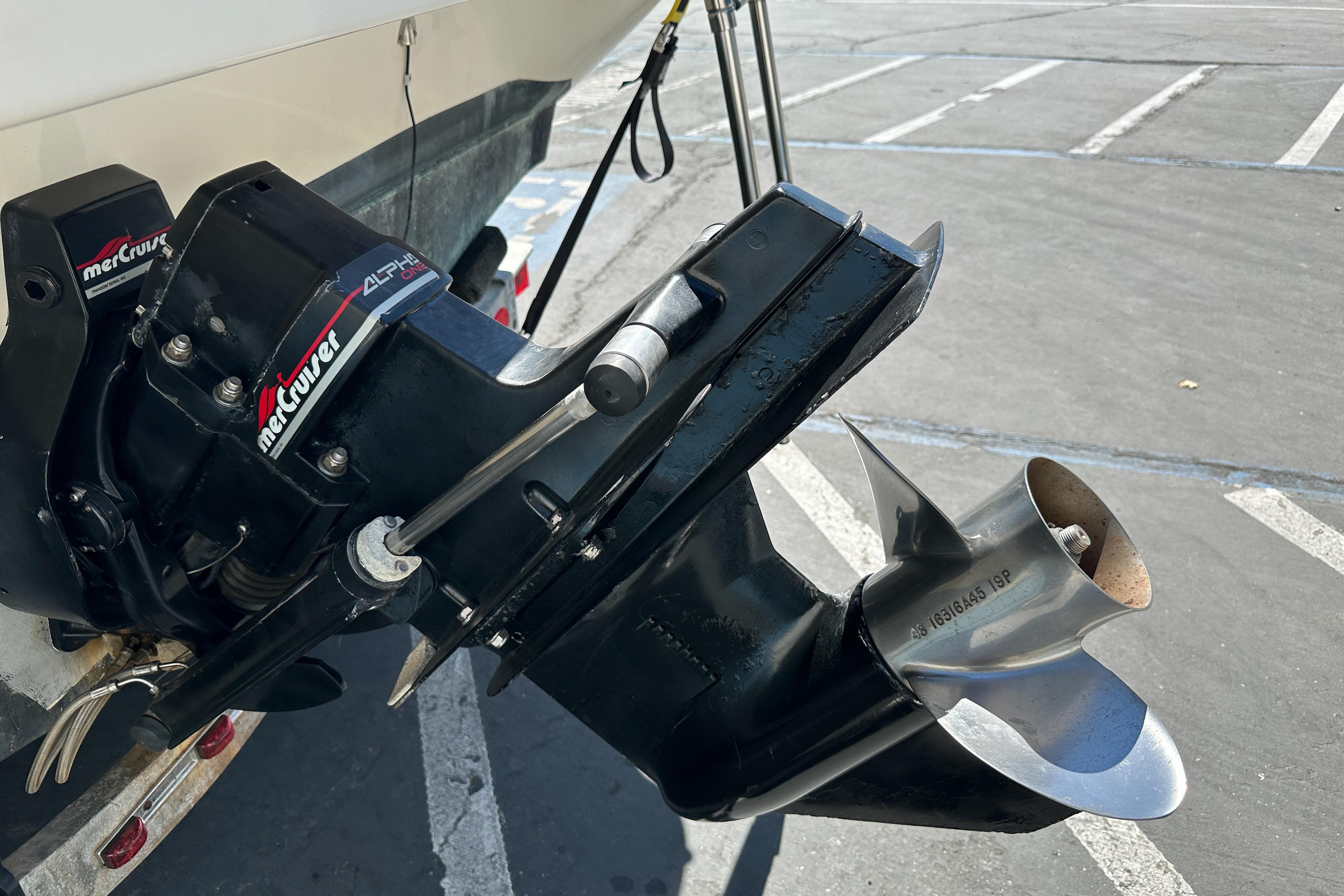 Outboard motor of a 1998 Sea Ray 215 Express Cruiser in a parking lot.