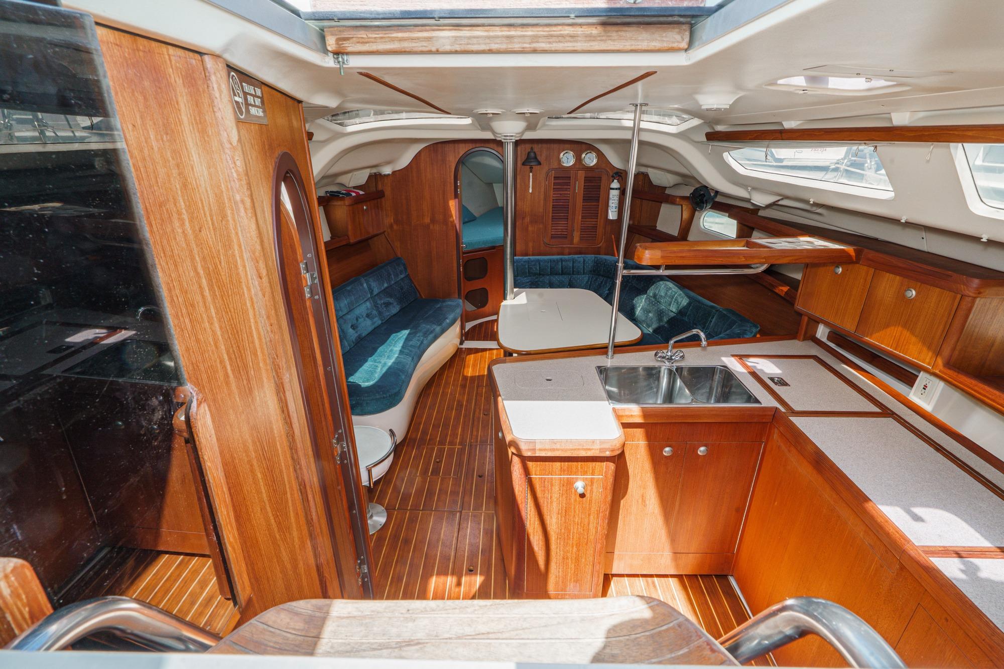 Interior of a 1996 Hunter 376 sailboat with wood finish and compact kitchen.