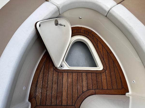 2014 Chris-Craft 28 LAUNCH boat interior with open storage compartment and wooden flooring.