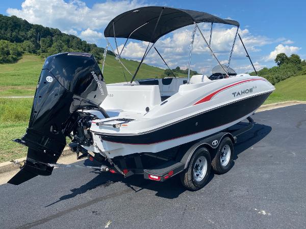 2024 Tahoe 2150 boat with canopy on a trailer, parked on a sunny day.