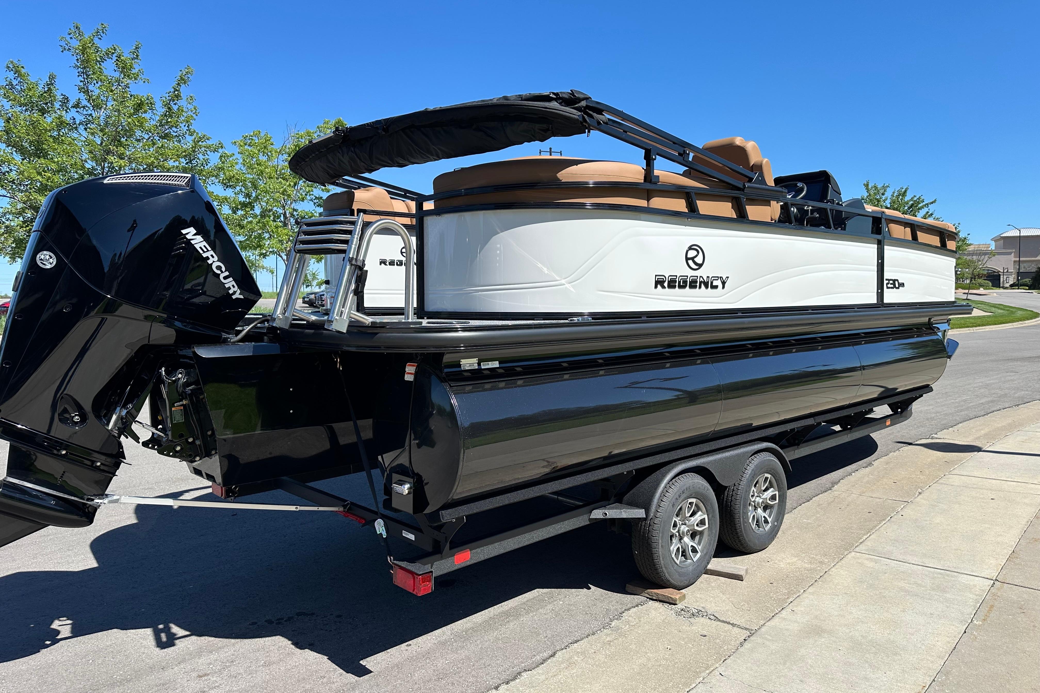 2026 Regency 230 DL pontoon boat on trailer, featuring Mercury outboard motor.