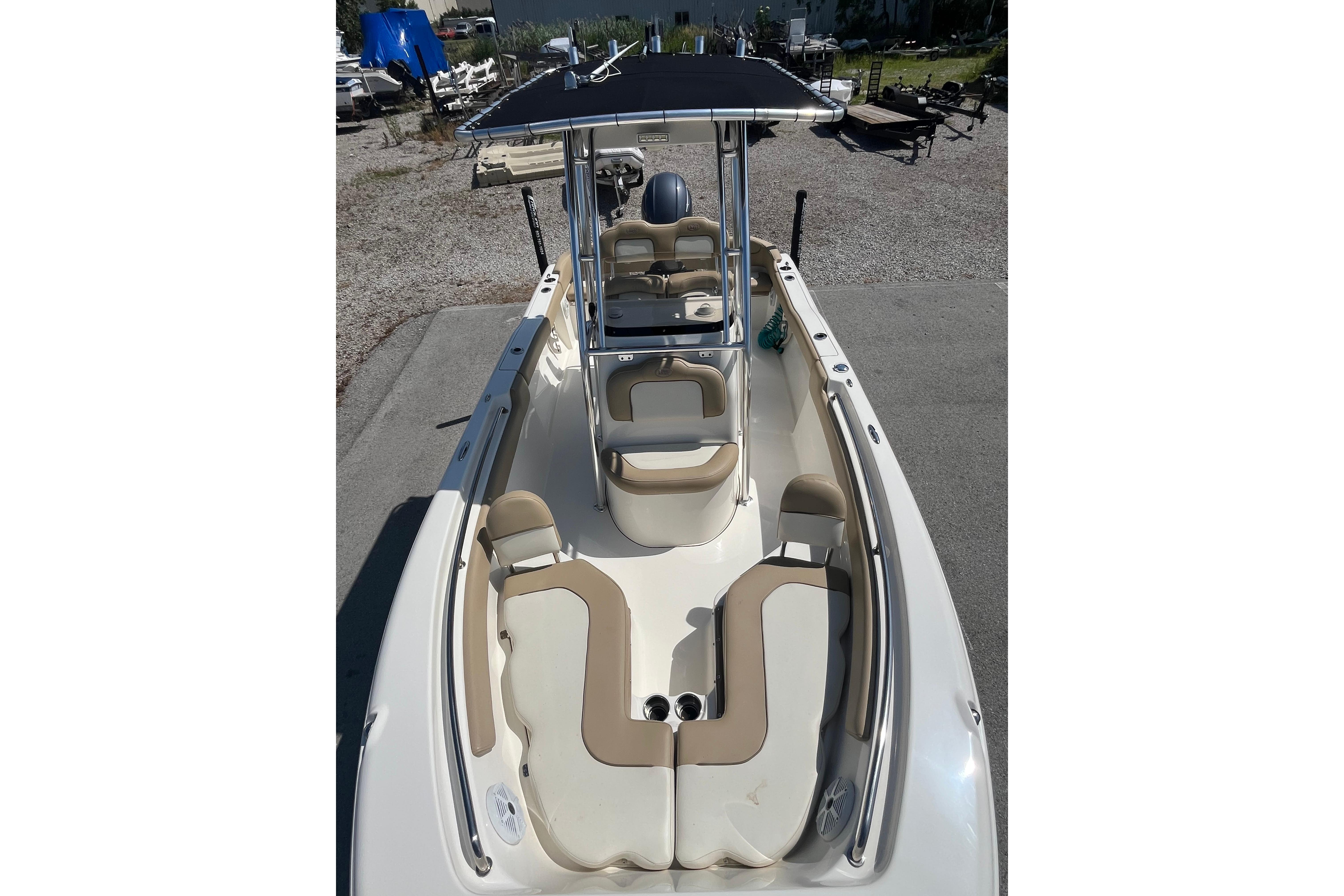2017 Key West 203 FS boat with beige seating and T-top, parked on gravel.