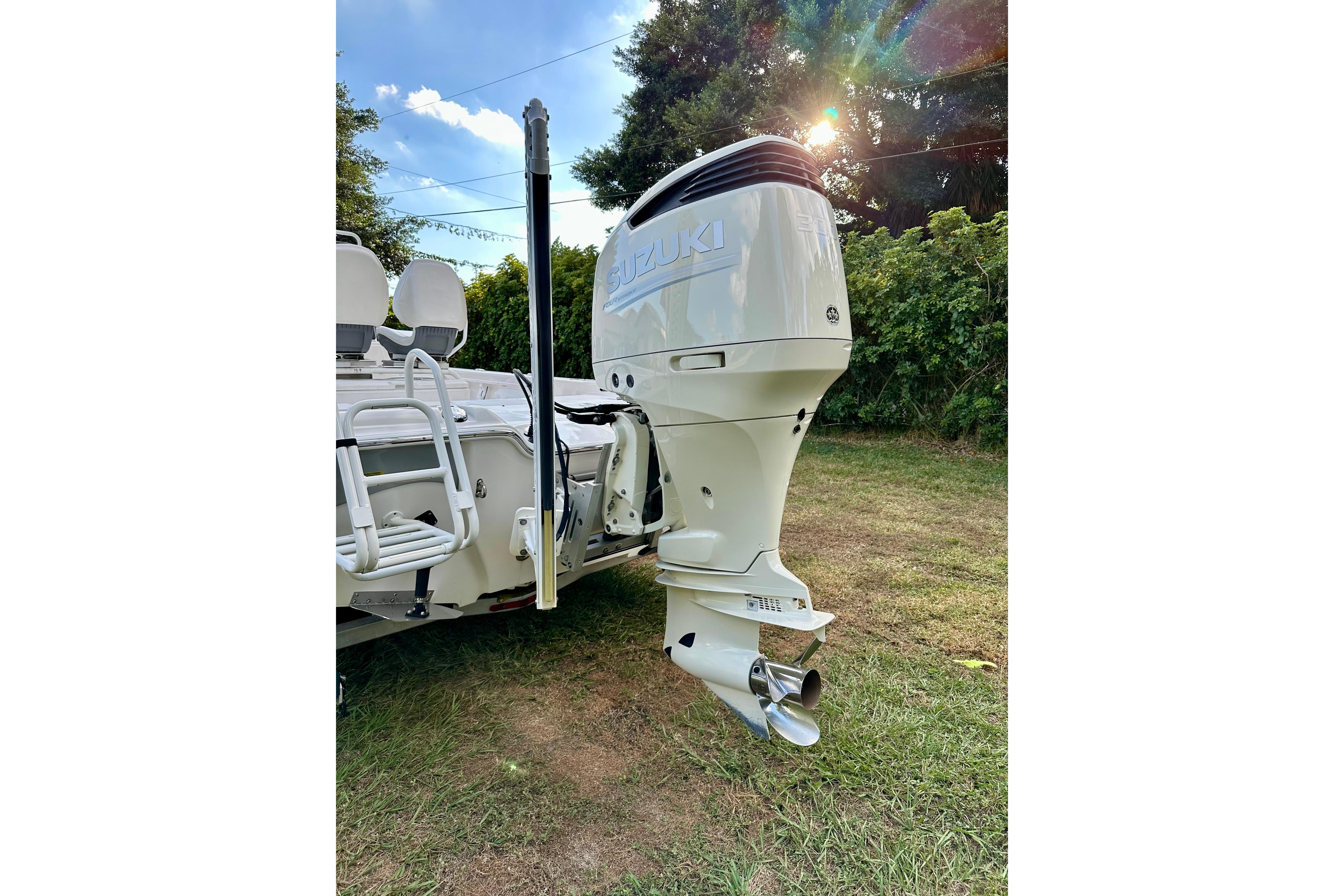 2017 Blue Wave 2400 PureBay boat with Suzuki outboard motor in a grassy area.