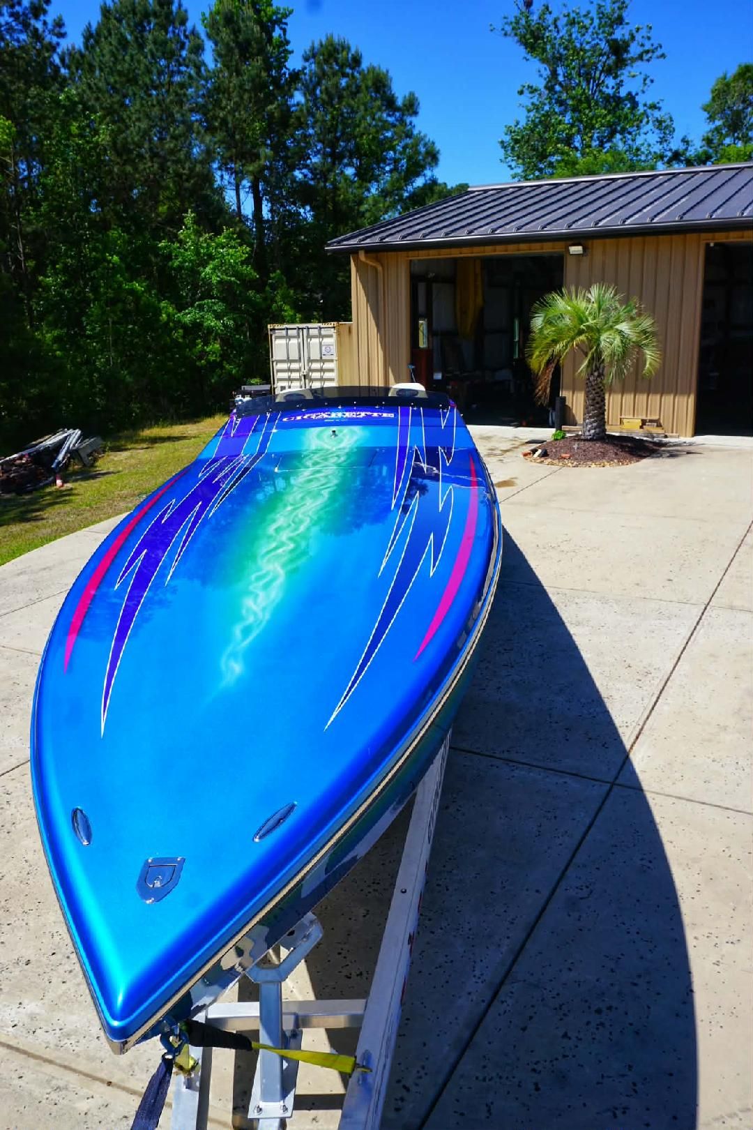 2018 Cigarette TopGun Unlimited boat on trailer in front of garage.