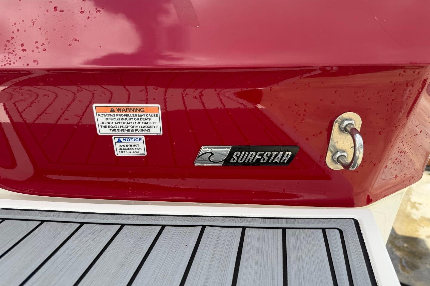 2023 MasterCraft X24 boat rear with SurfStar logo and safety warnings.