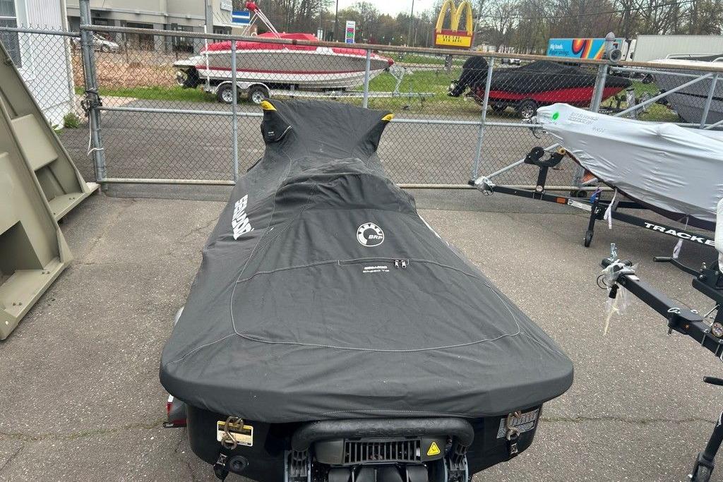 2014 Sea-Doo Wake Pro 215 covered, parked in a lot with trailers nearby.