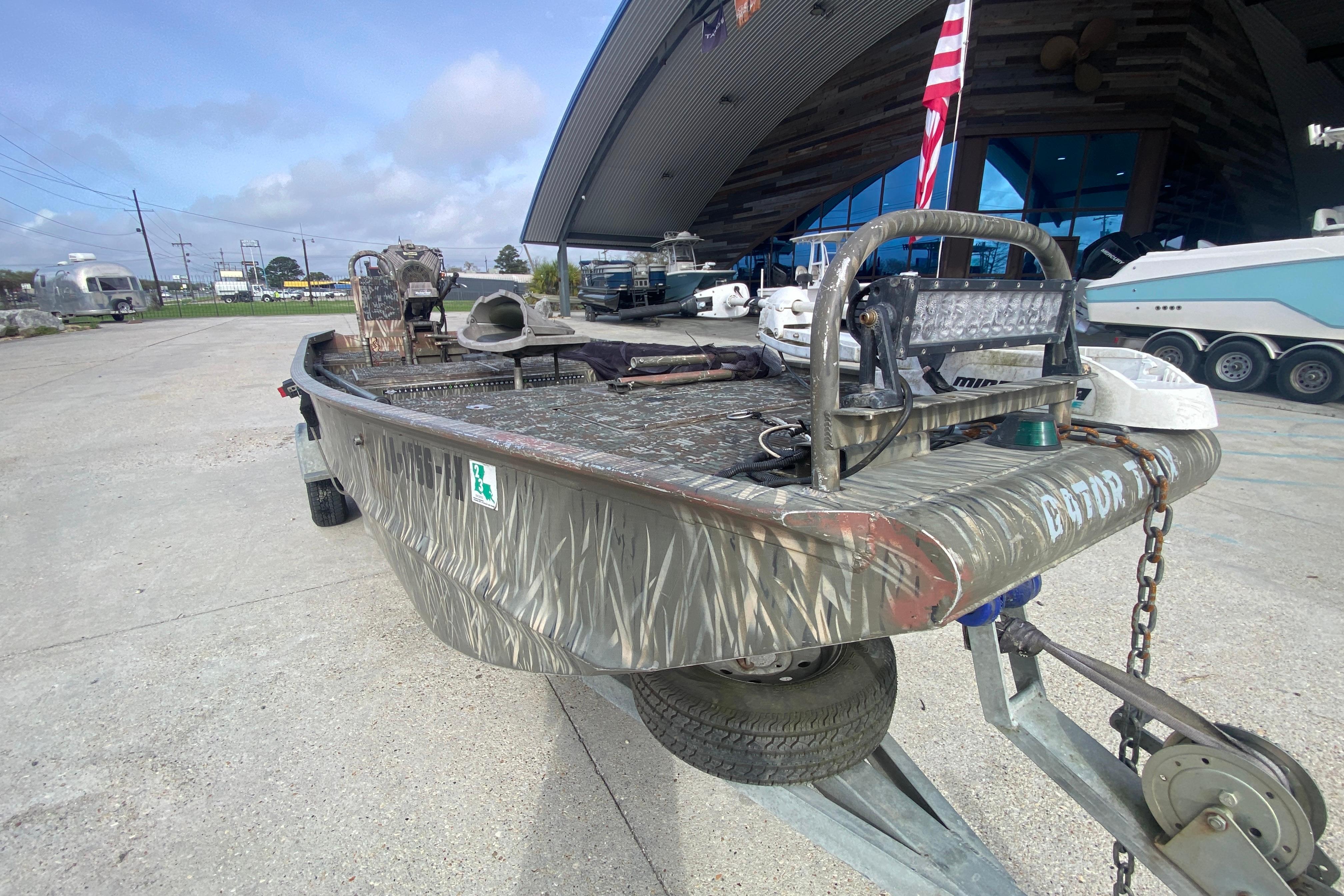 2009 Gator Trax MUD BUDDY 17 X 50 boat on trailer, camo design, outdoor setting.