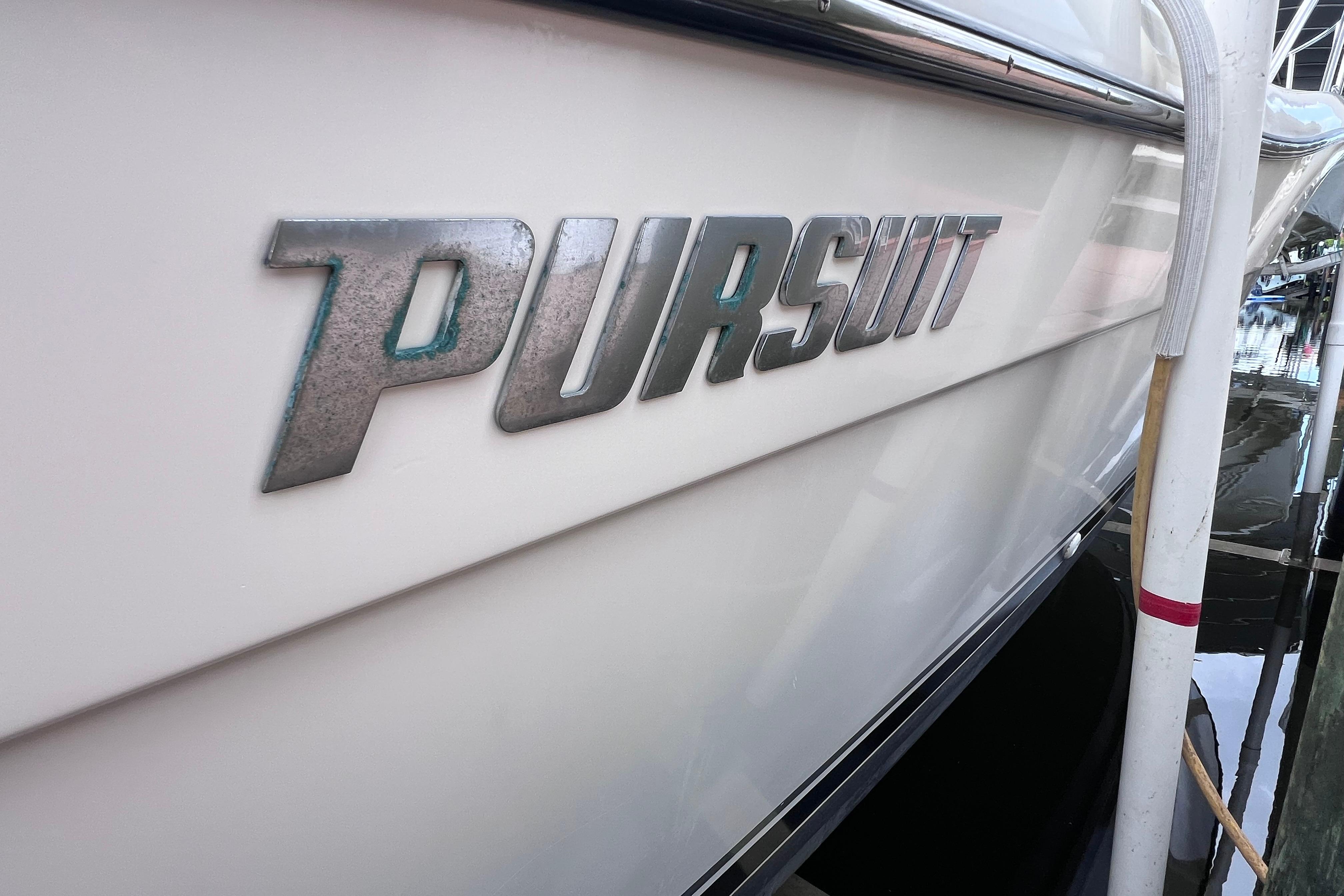 2005 Pursuit 3070 Offshore boat with metallic logo on the side.