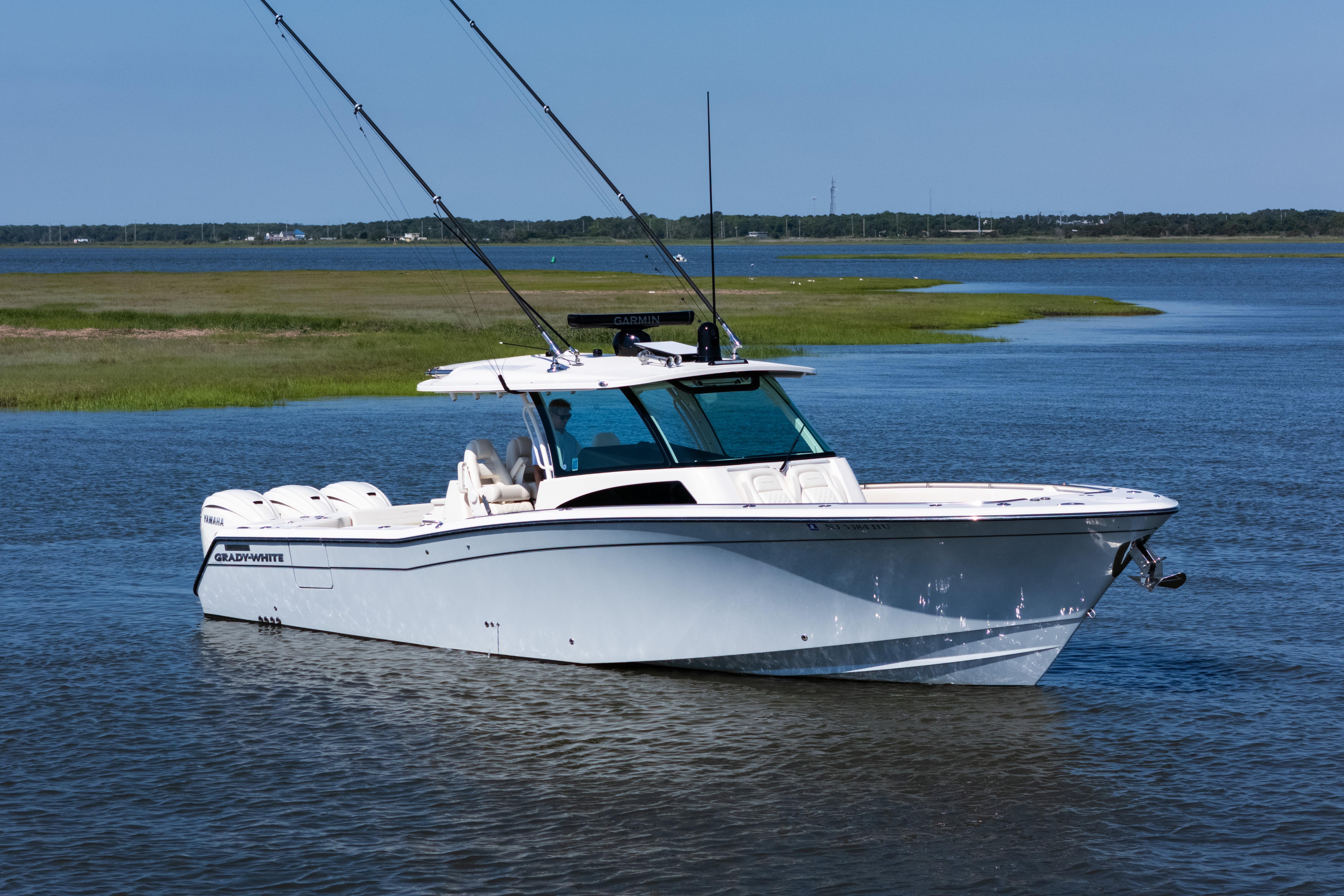 2025 Grady-White Canyon 386 boat on calm water, featuring sleek design and fishing rods.