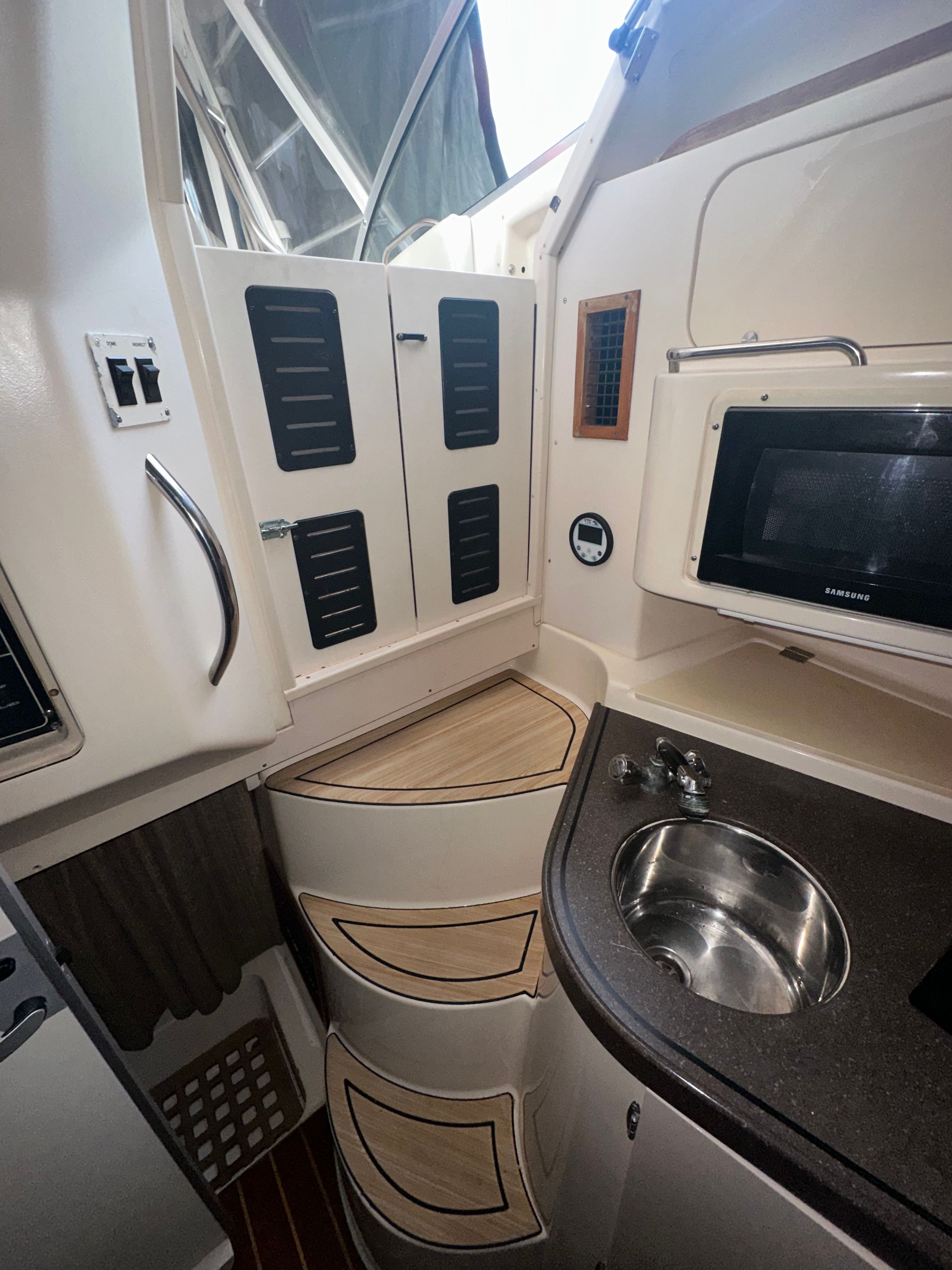 Interior of the Grady-White Express 330 with sink, microwave, and storage.