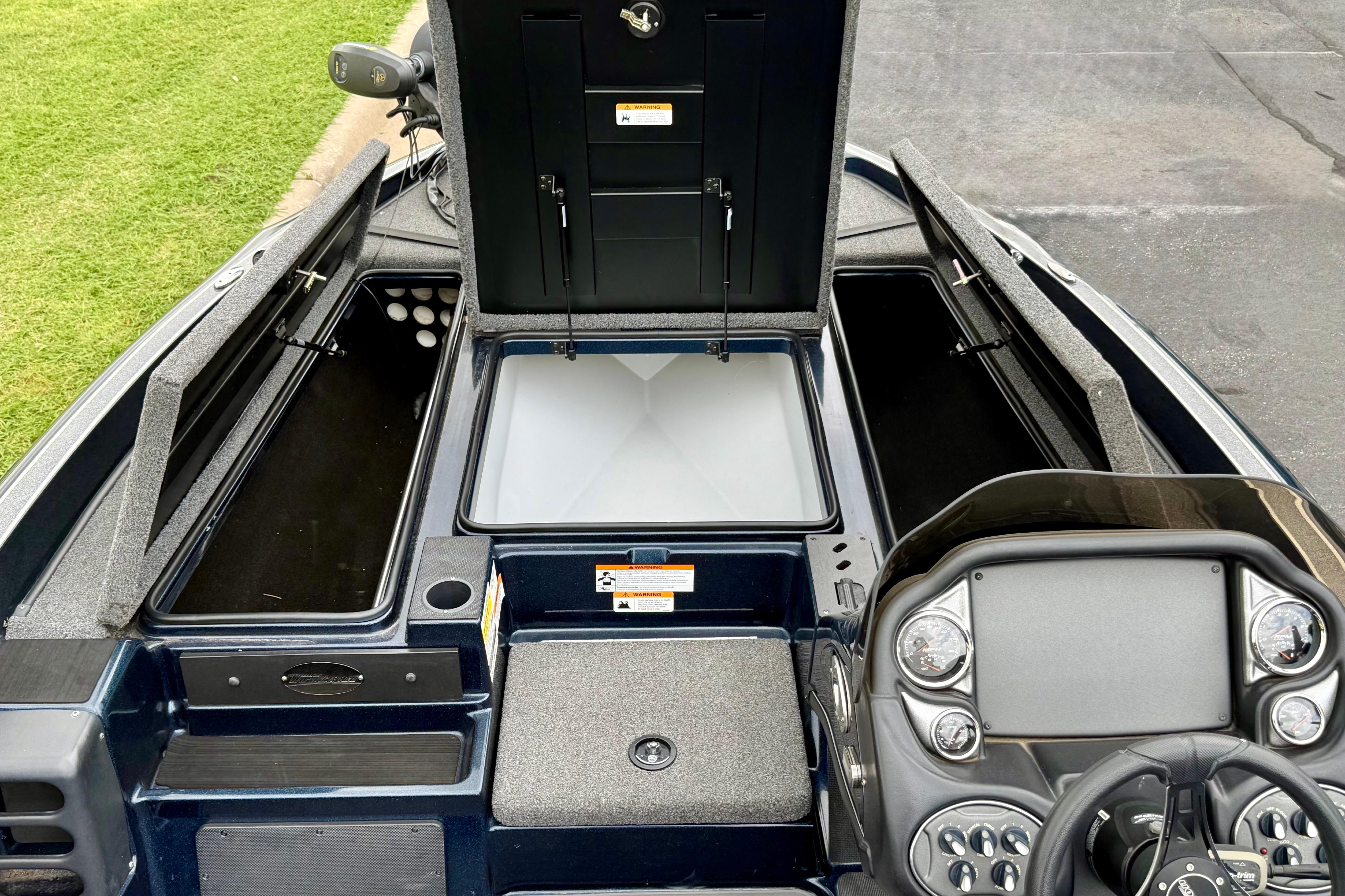 2023 Triton 18 TrX boat interior with open storage compartments and control panel.