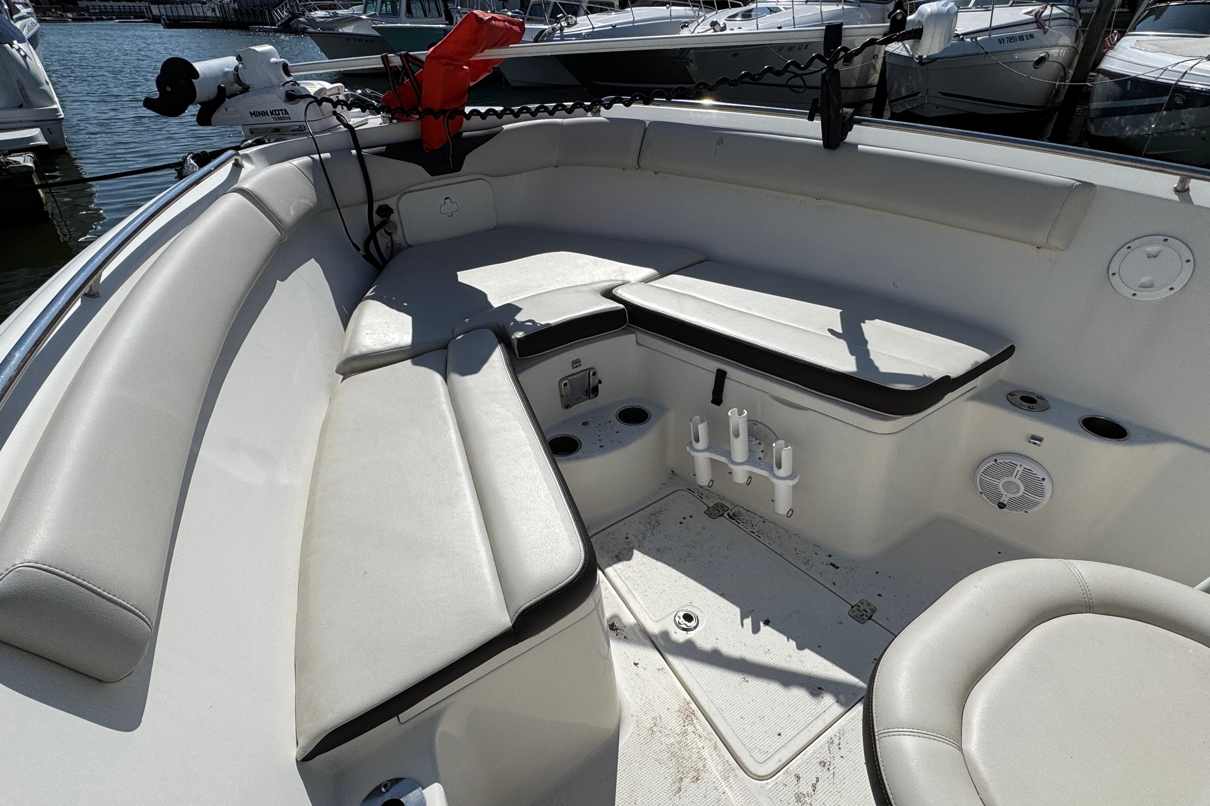 Interior view of 2022 Sailfish 242 CC boat with cushioned seating and fishing rod holders.
