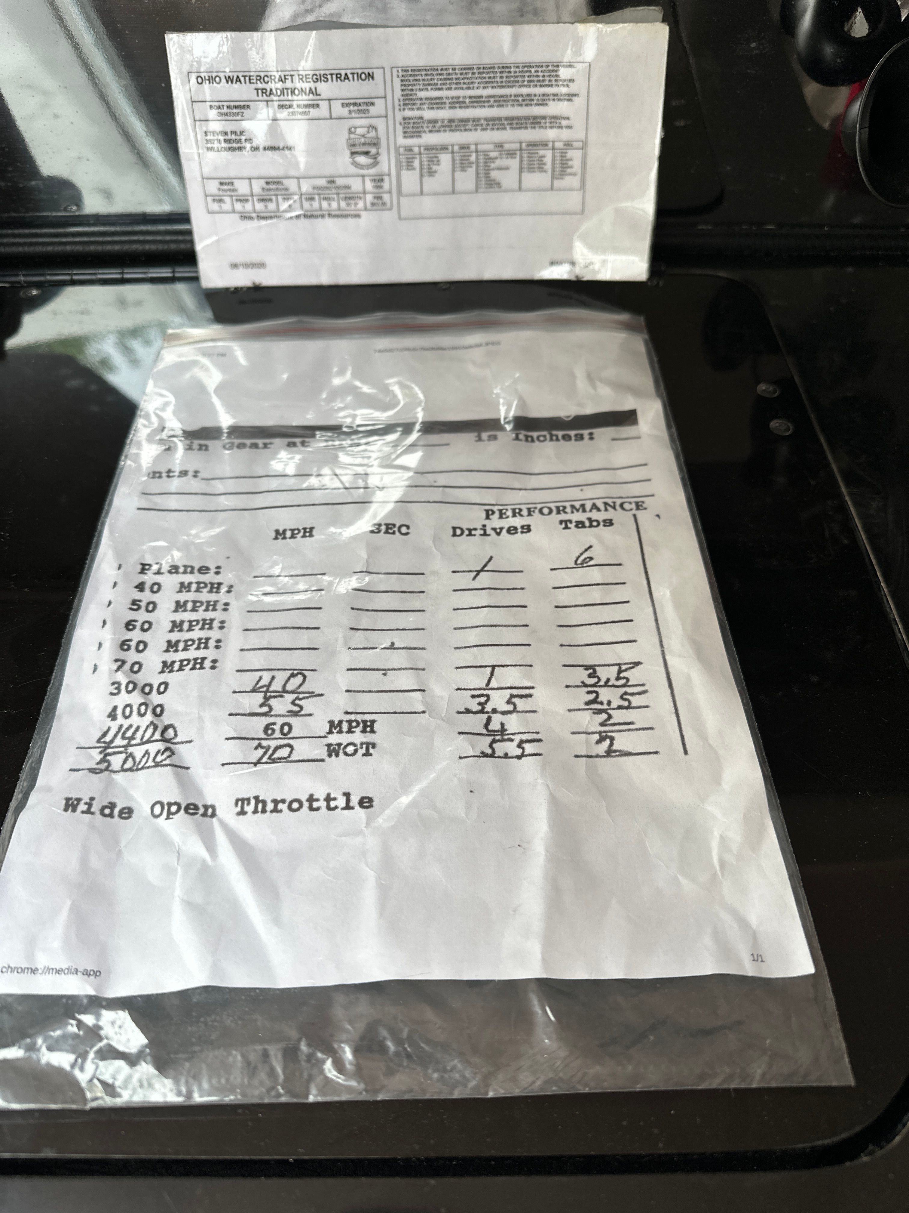 A document with performance data and speeds for a boat, lying on a table.