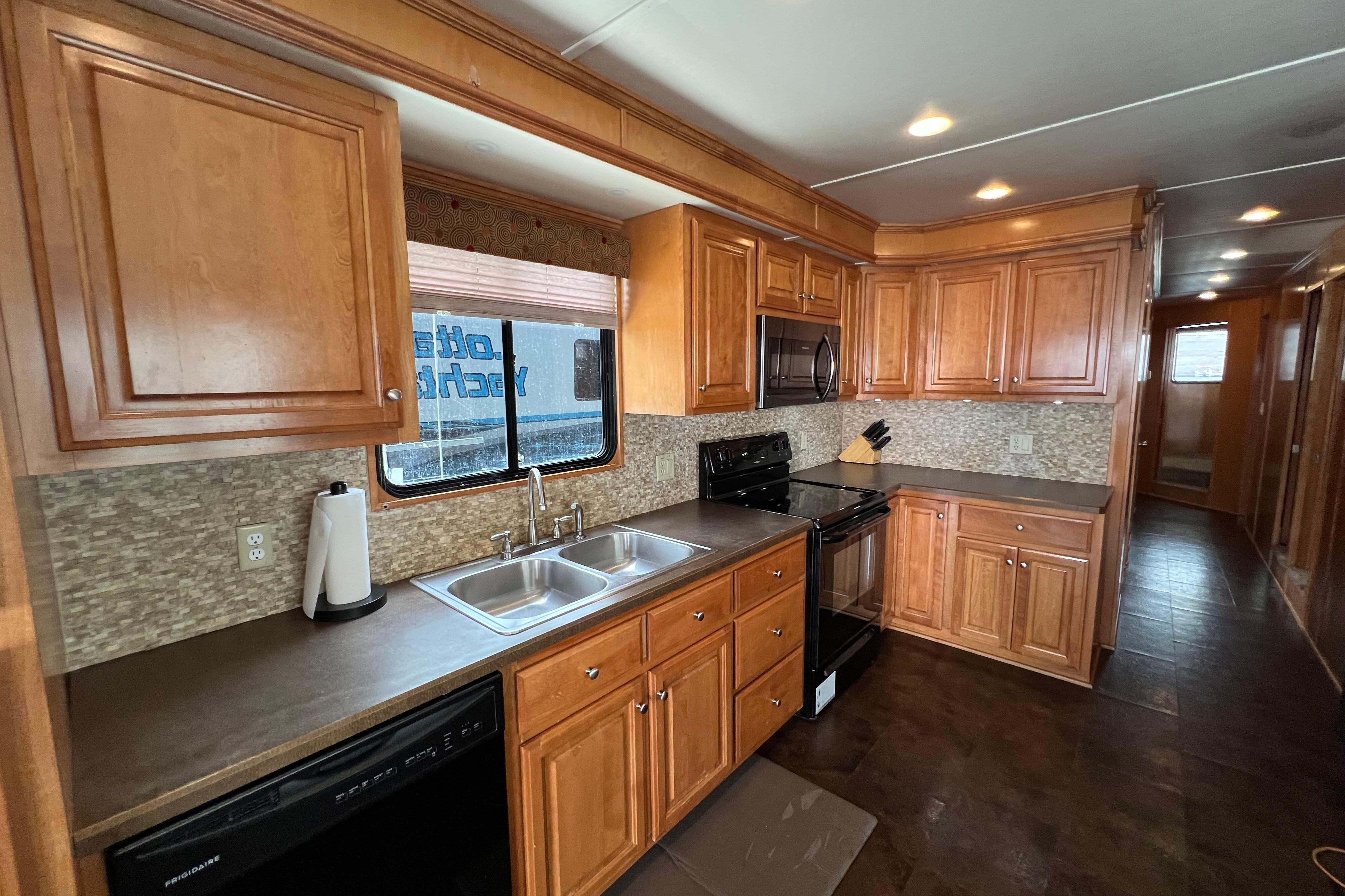 Luxurious 2013 Destination Yacht Lotta Yachta kitchen with wooden cabinets and modern appliances.